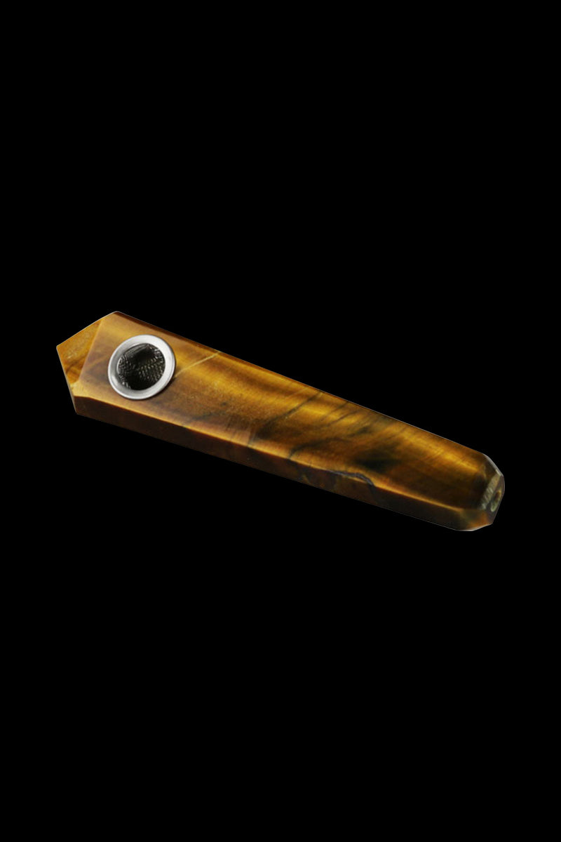 Angled close-up of a brown, faceted Natural Gemstone Mineral Hand Pipe set against a black background, showing its metal bowl and polished stone grain