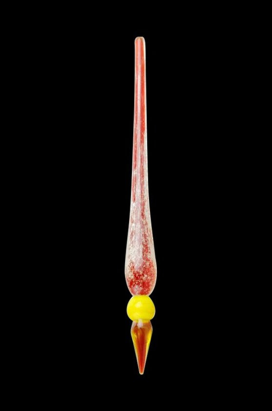 Vertical close-up of a red-tinted Glow in the Dark Dabber Tool with a yellow glass bead near its pointed tip against a black background