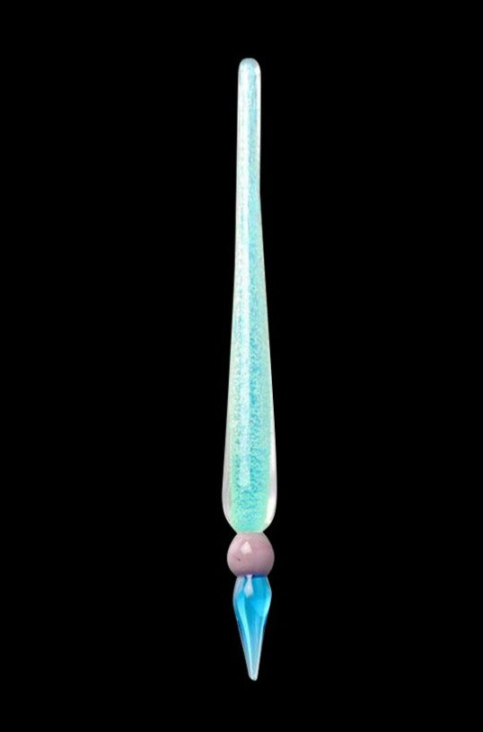 Single vertical studio shot of the Glow in the Dark Dabber Tool showing its long pale green glittering shaft, round pink bead and tapered blue tip against black background.