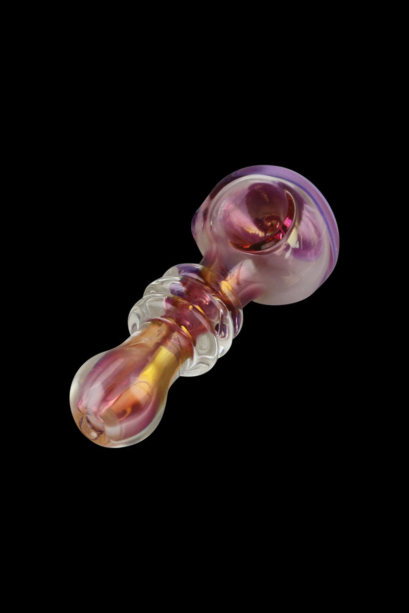 A close-up, angled view of the Gold Fumed Glass Spoon Pipe - Jetson, showing its curved shape and iridescent sheen against a dark background.