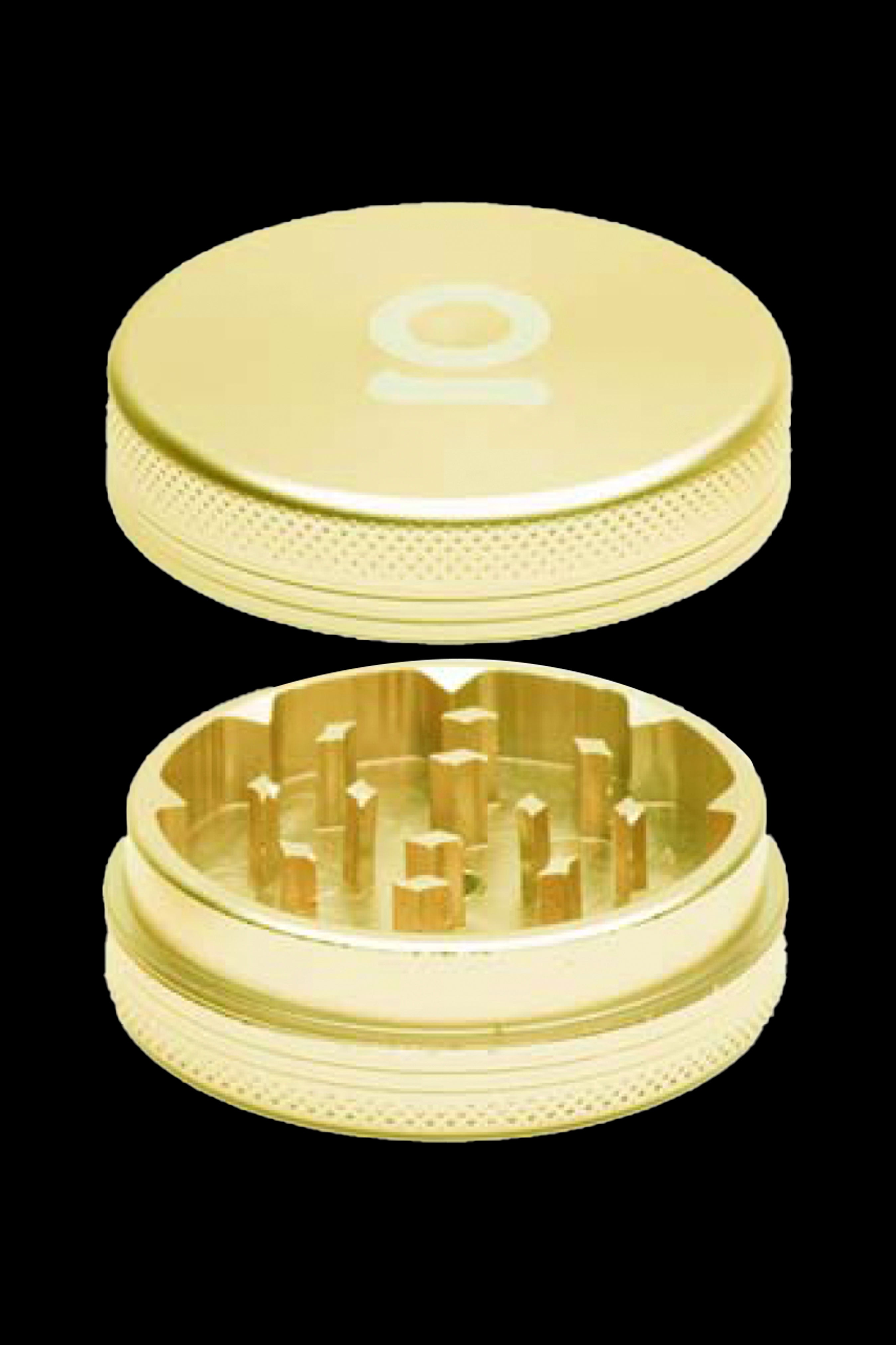 Gold cannabis grinder disassembled into two circular pieces, revealing the grinding teeth.