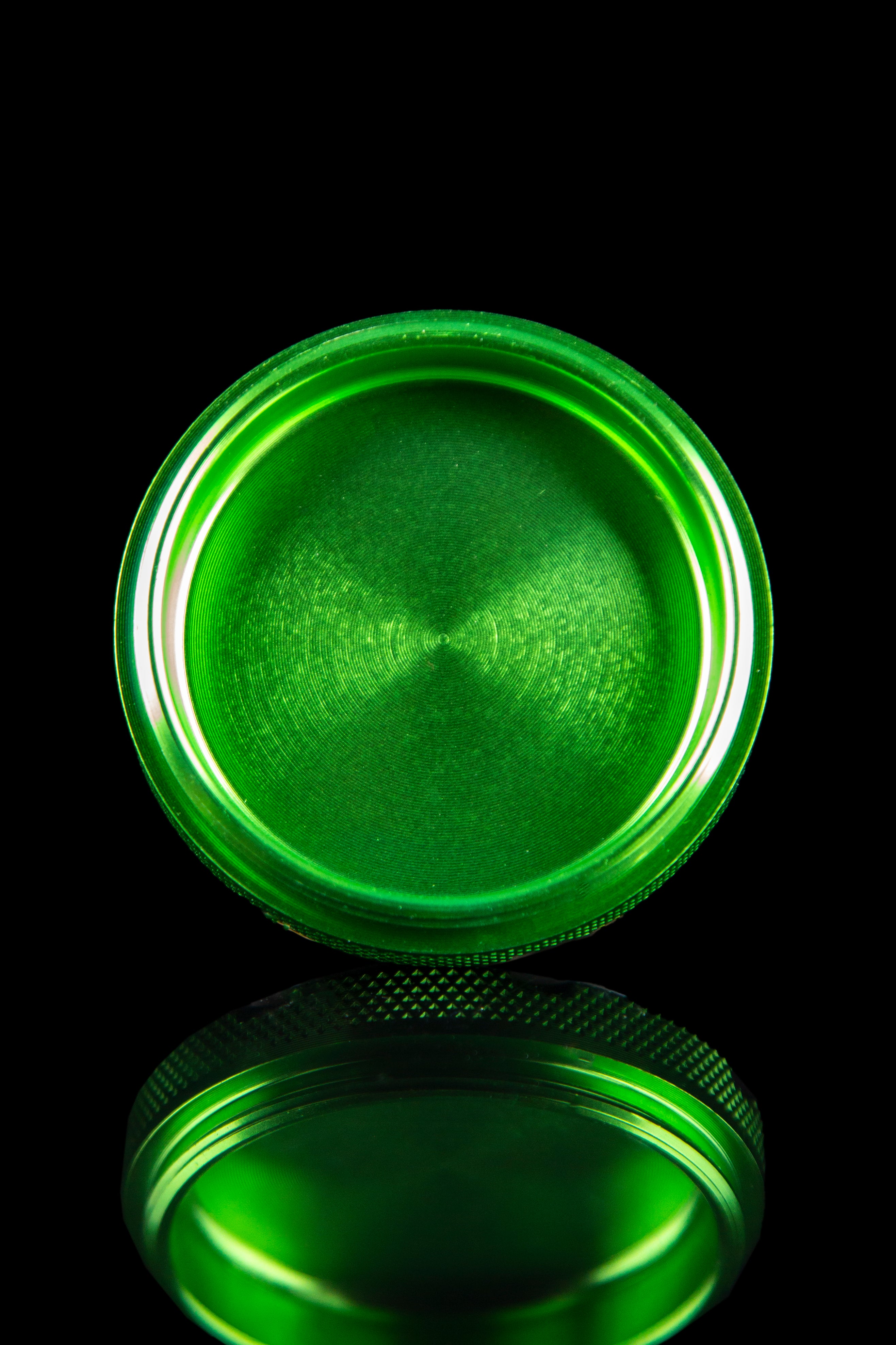 Close-up view of the open Famous X 4-Piece Grinder, showcasing its metallic interior and circular design against a black background.