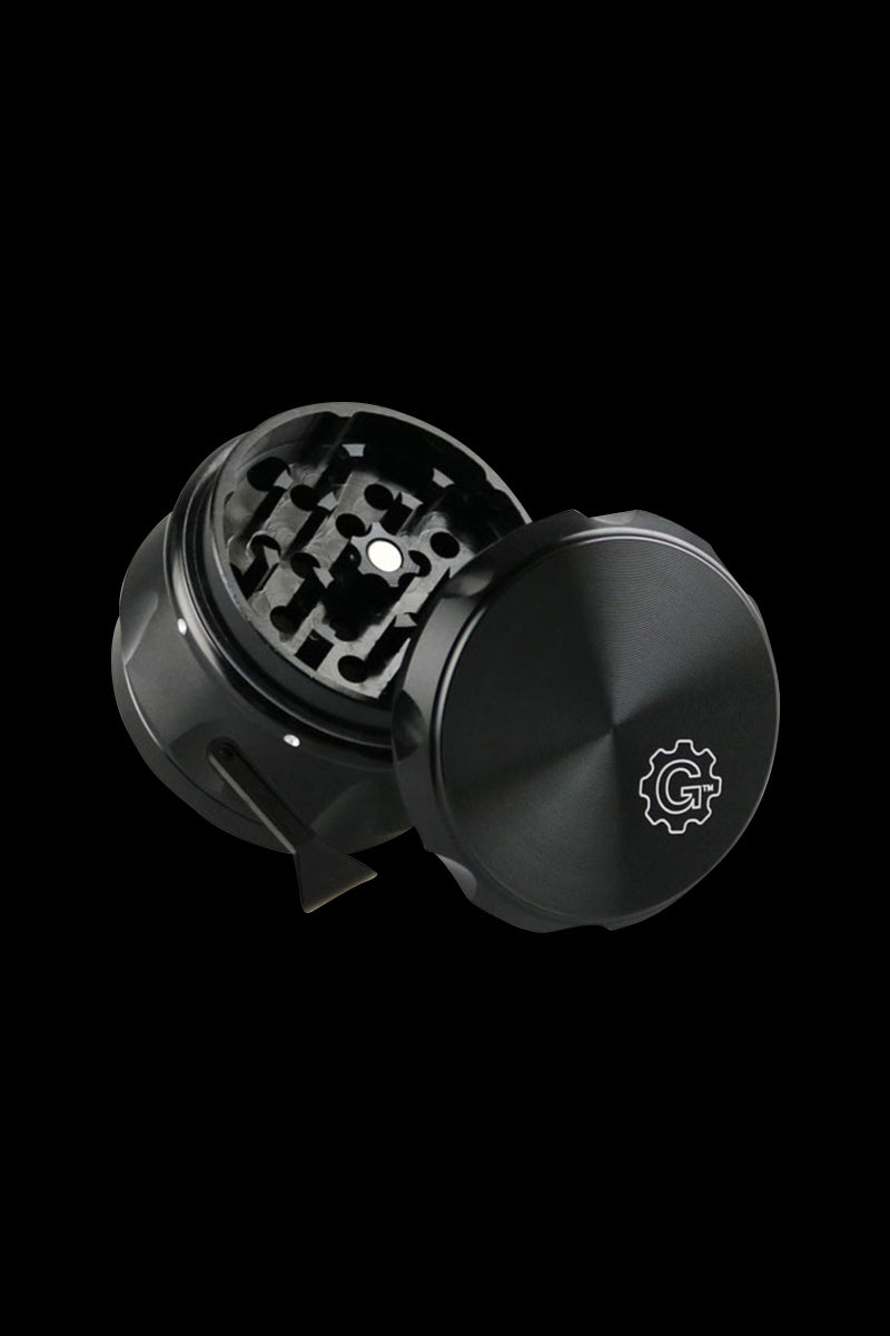 Angled close-up of the blue Pulsar Carver 4-Piece Grinder showing its open, textured lid with logo and the toothed grinding chamber against a black background