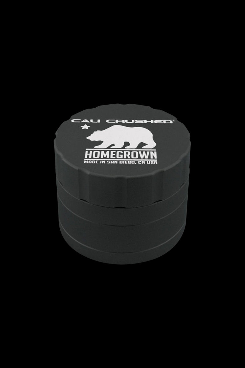 Centered front-angle view of the black Cali Crusher Homegrown 4 Piece Grinder with Quicklock showing its stacked cylindrical layers and white bear logo on the lid.