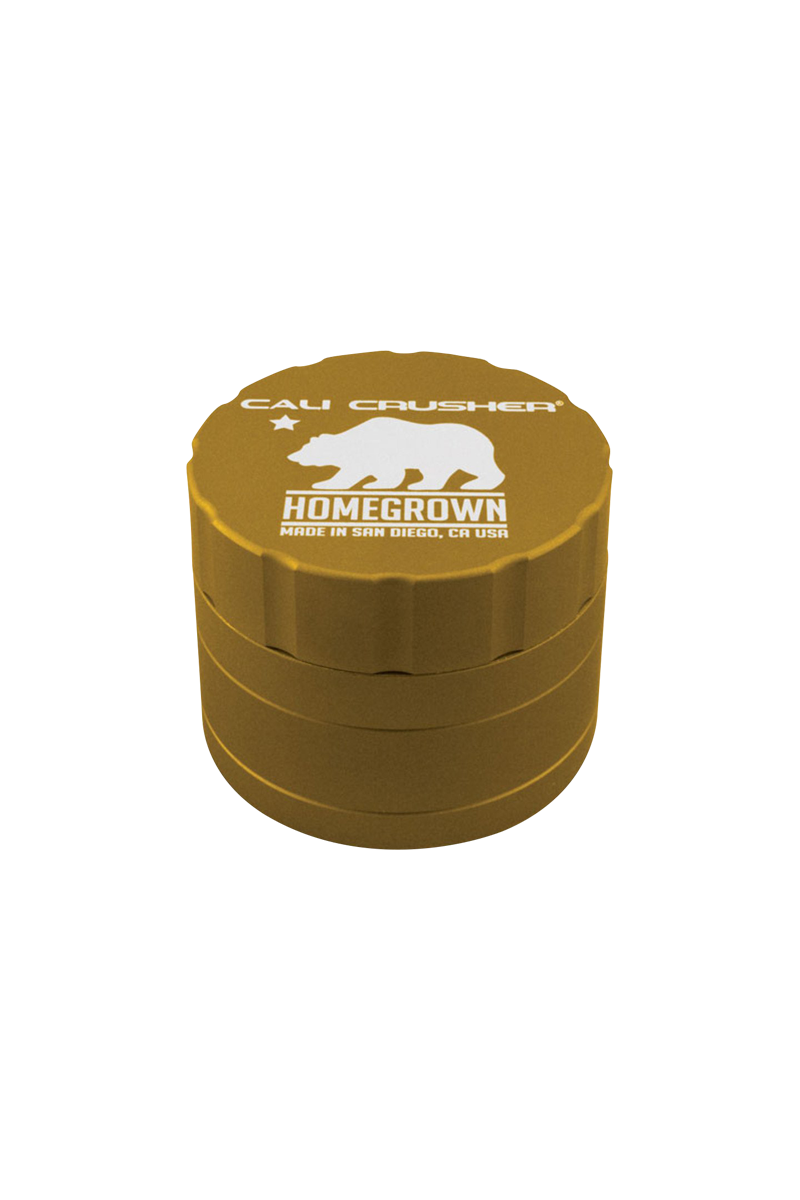 Top-down view of a gold Cali Crusher Homegrown 4 Piece Grinder with white bear logo and scalloped lid edge.