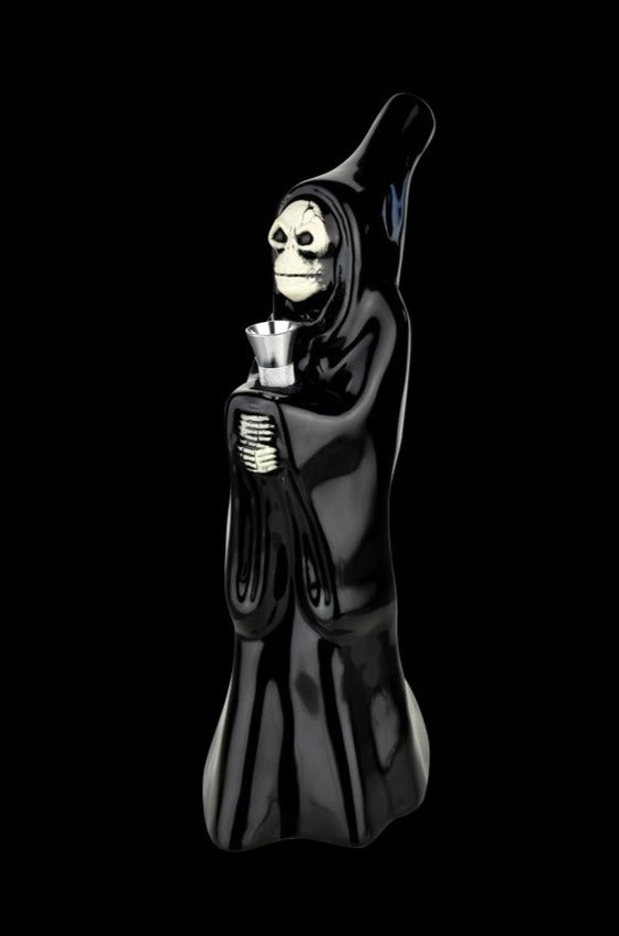 Three-quarter view of the Ceramic Bong - Skeleton Cupbearer, a glossy black hooded skeleton figure holding a metal cup against a black background