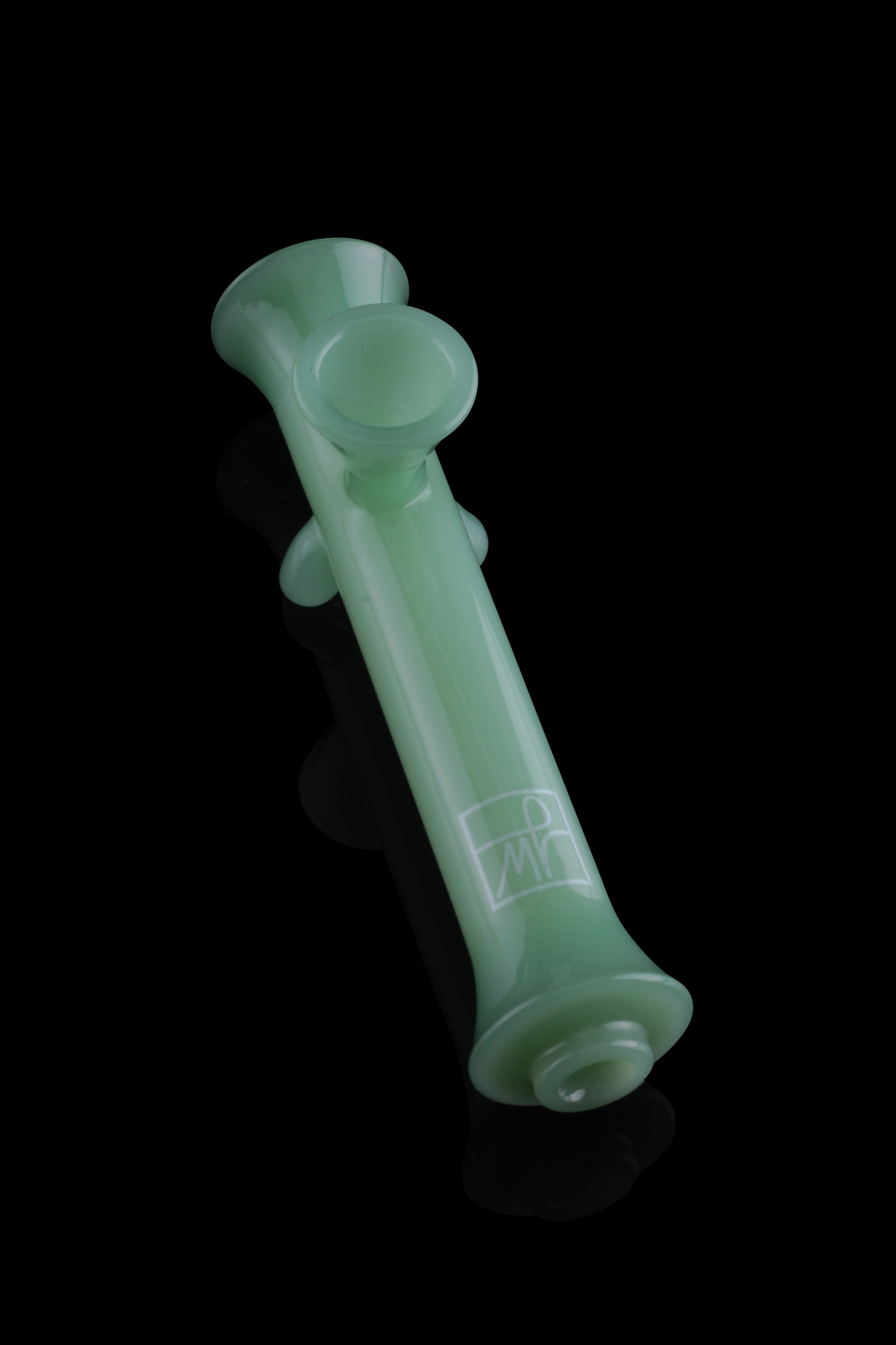 Green glass cannabis pipe isolated on a black background.