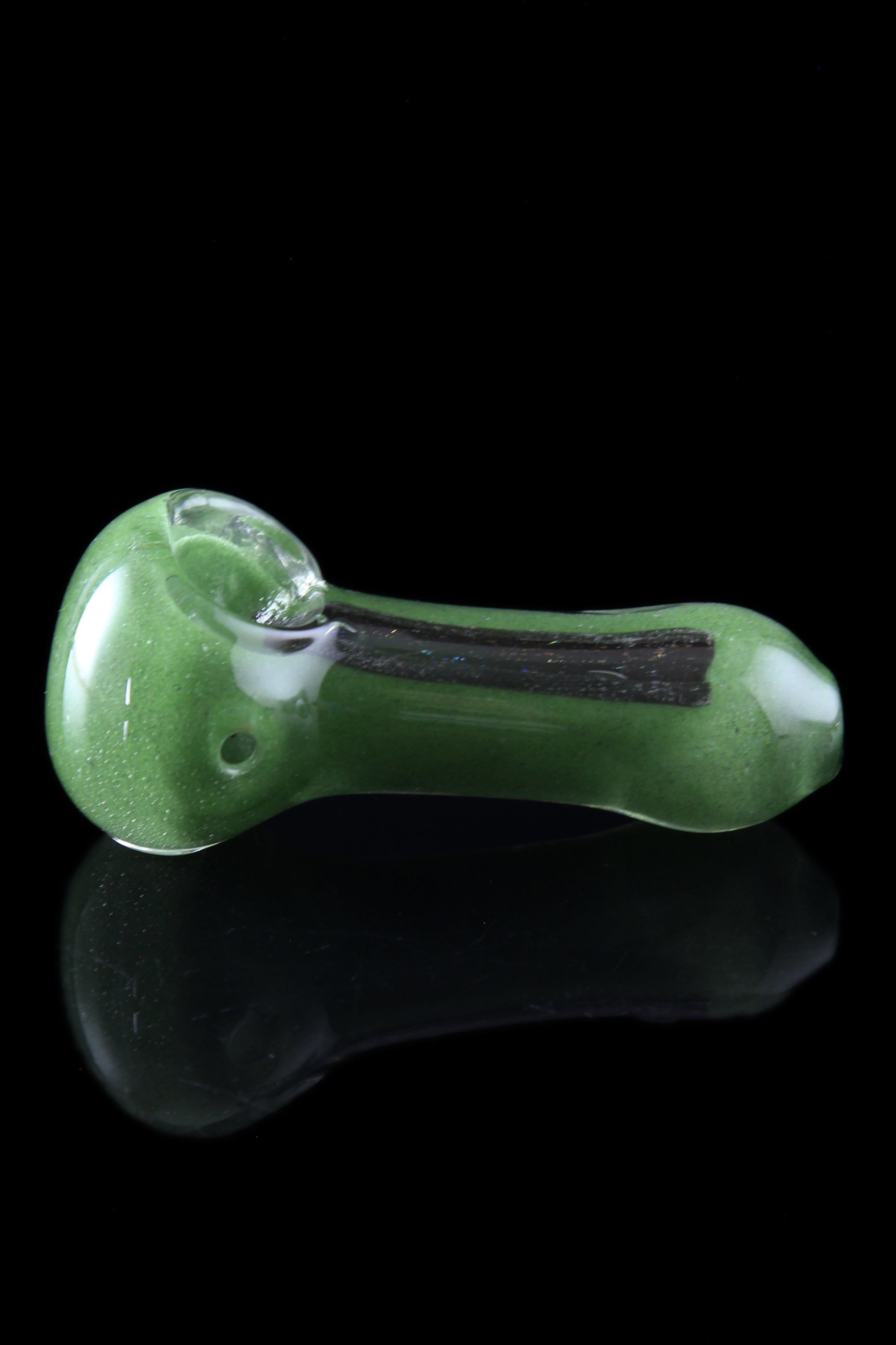 Green glass pipe with black accents, reflecting on a glossy surface.