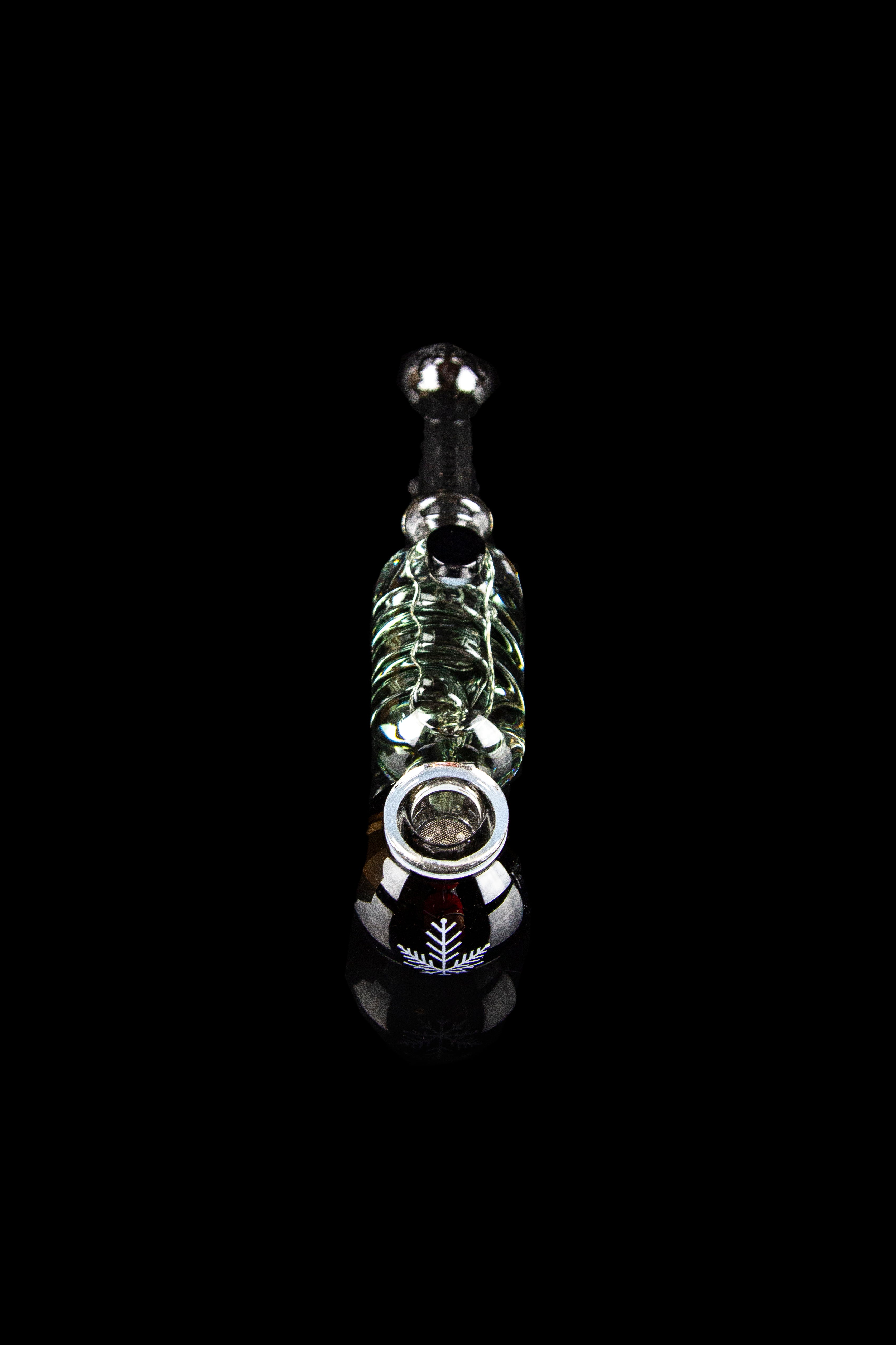 Glass cannabis oil rig with intricate green and white detailing, displayed against a black background.