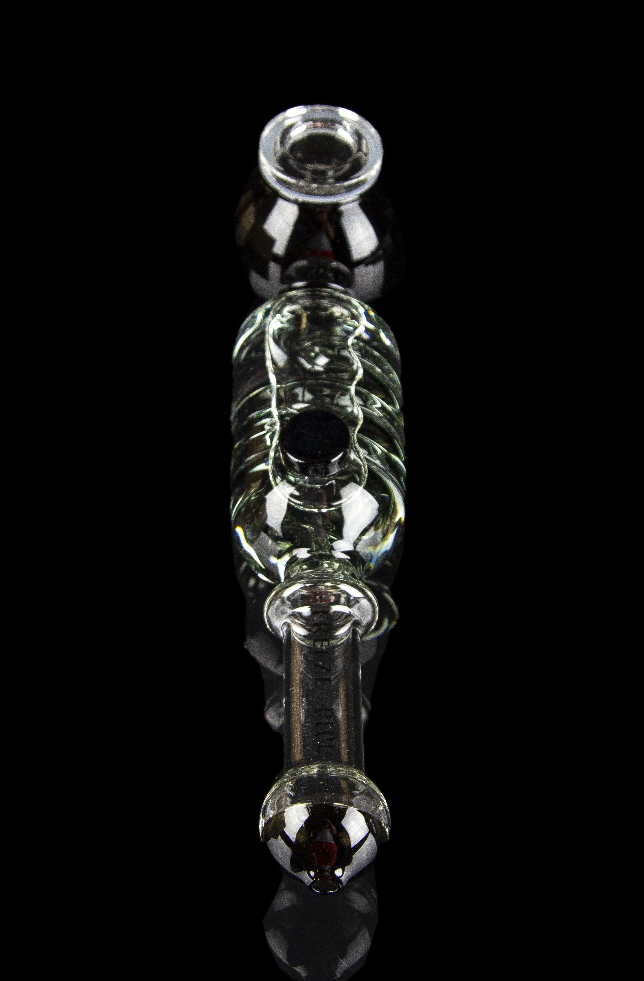 Glass bubbler with green accents and red mouthpiece, isolated on black.