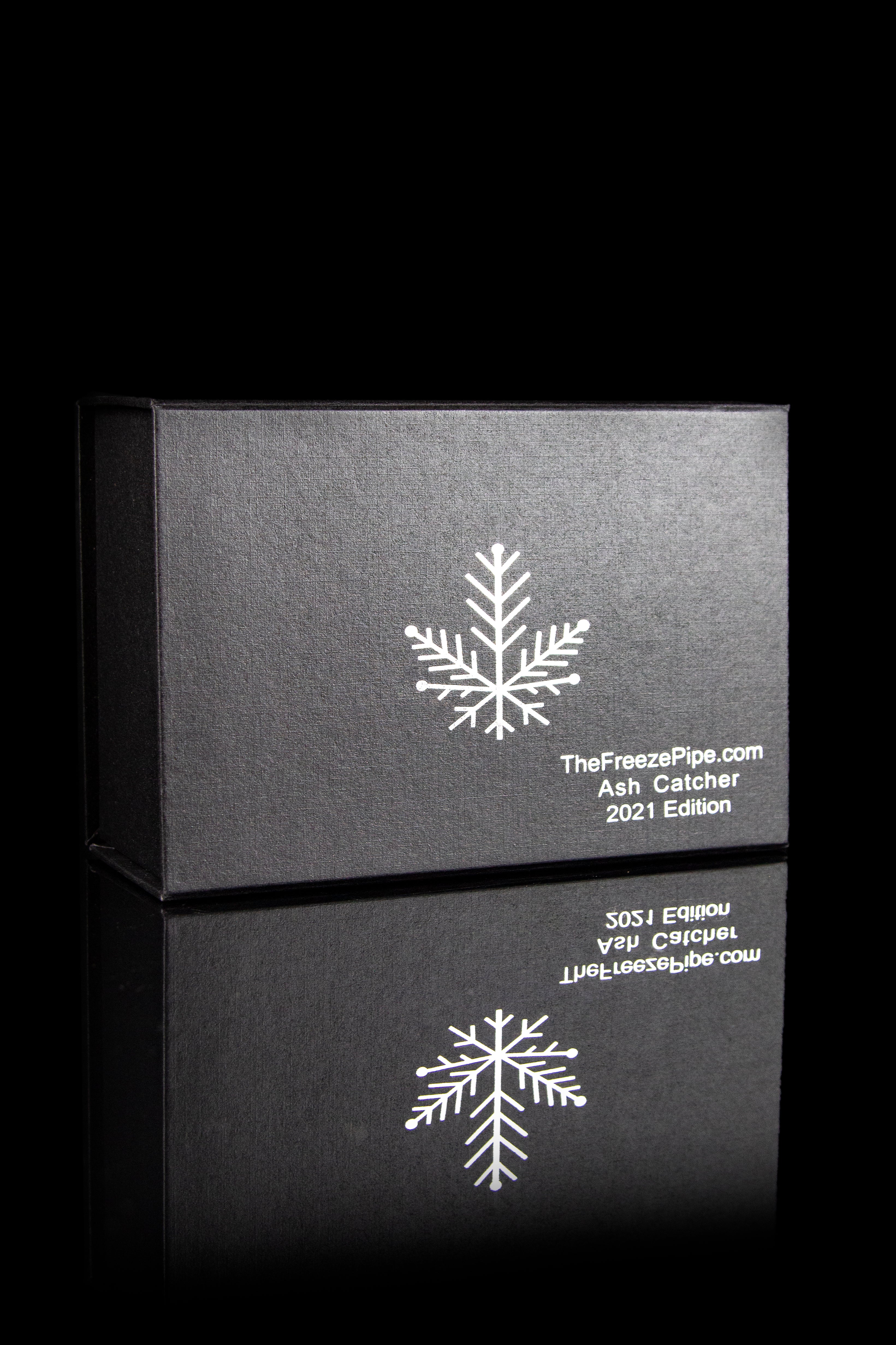 Black boxes with snowflake designs and branding for “TheFreezePipe.com Ash Catcher 2021 Edition.”