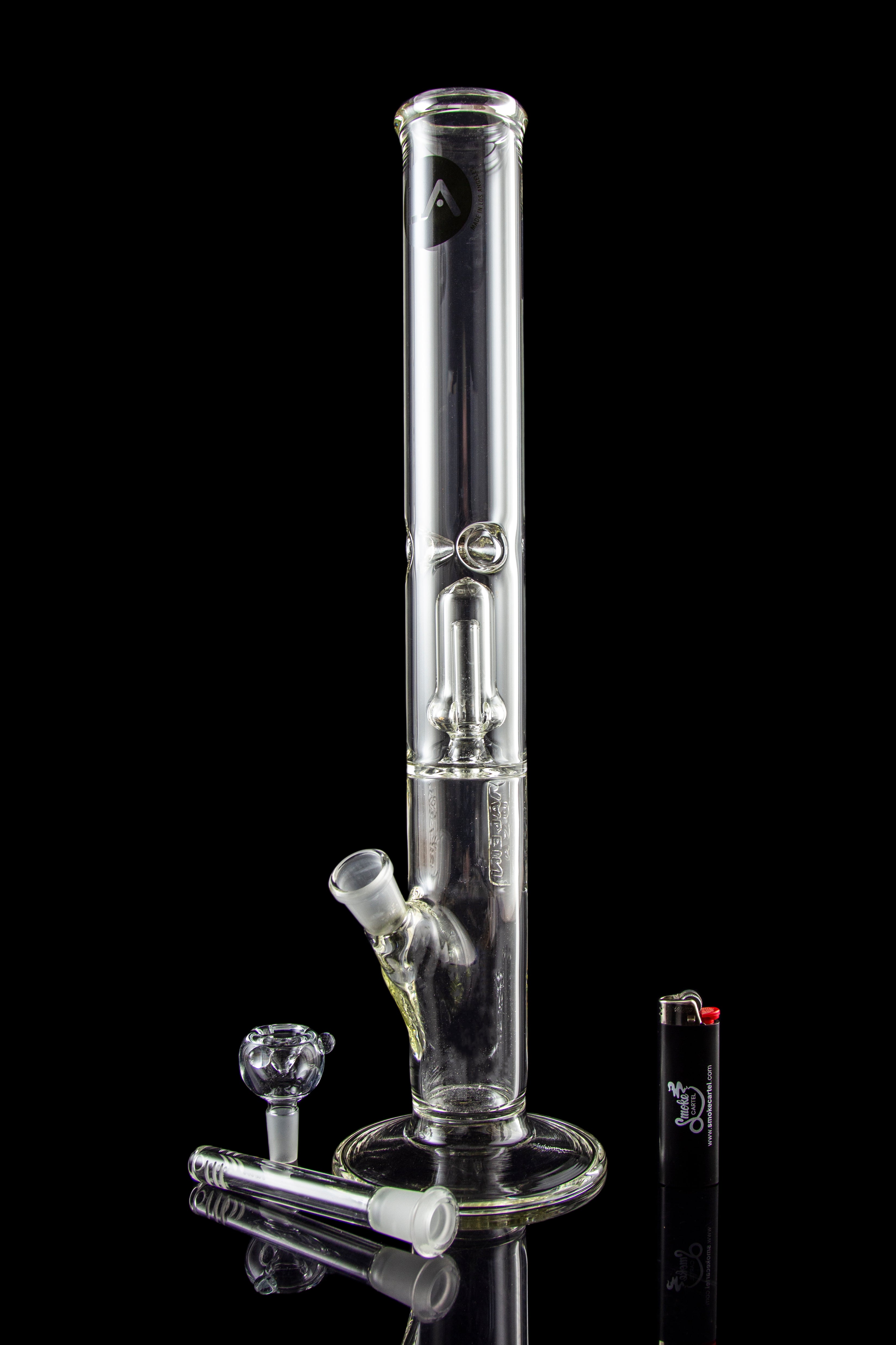 Glass bong with accessories and lighter on black background.
