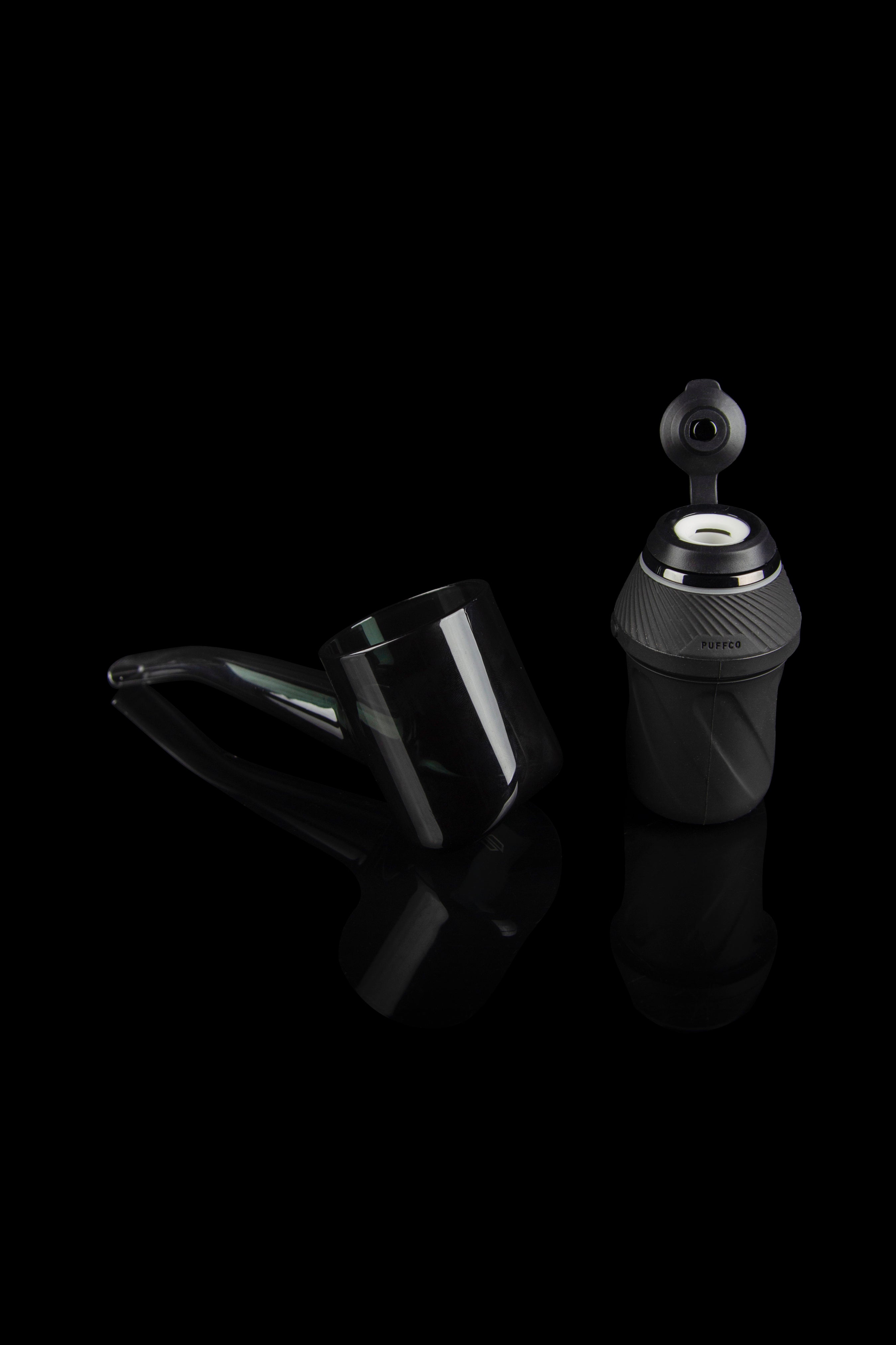 Puffco Peak Pro portable dab rig with accessories on a reflective surface.