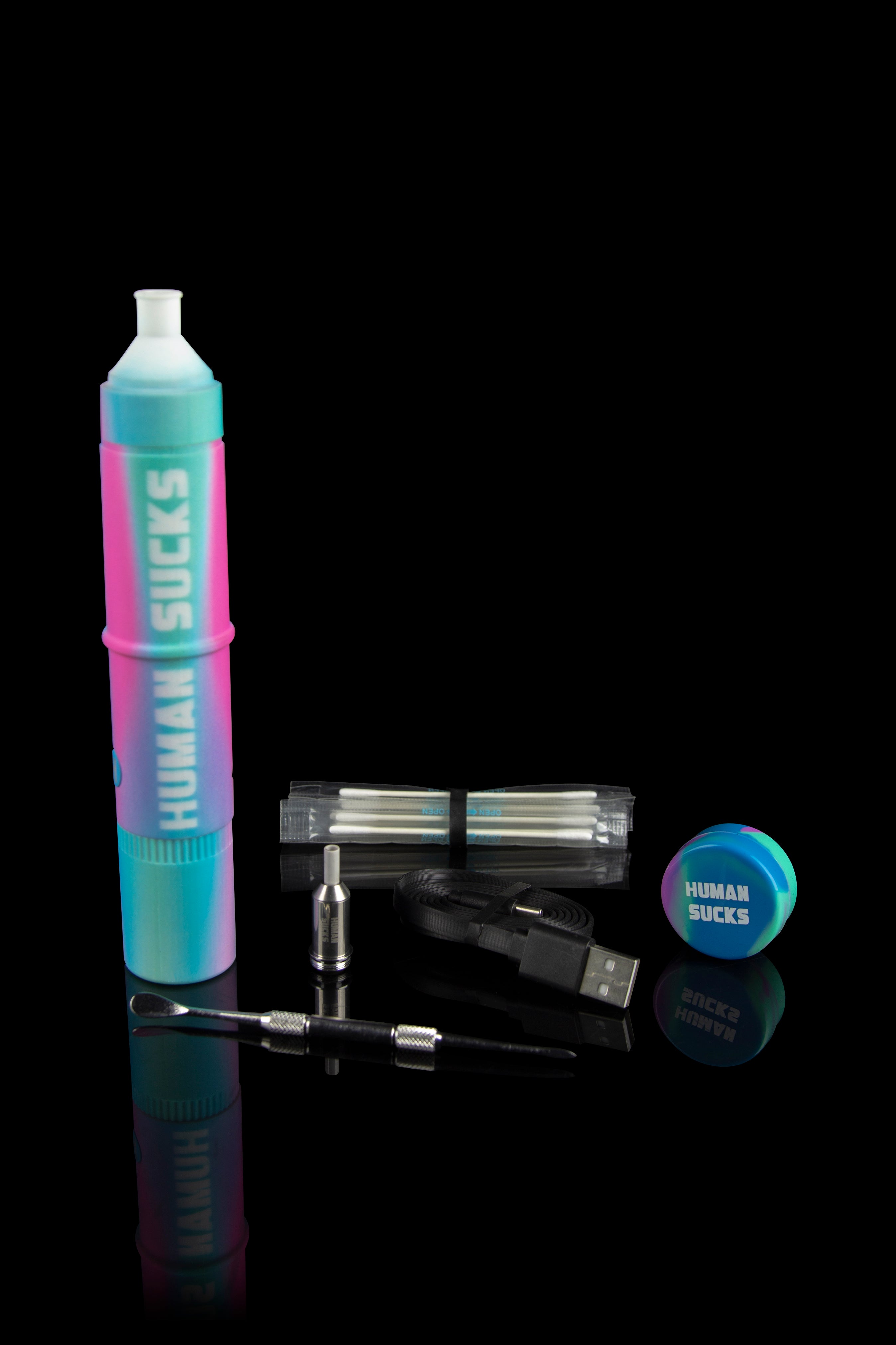 A colorful, cylindrical cannabis dab rig with accompanying tools, cartridges, and a charging cable, displayed on a reflective surface.