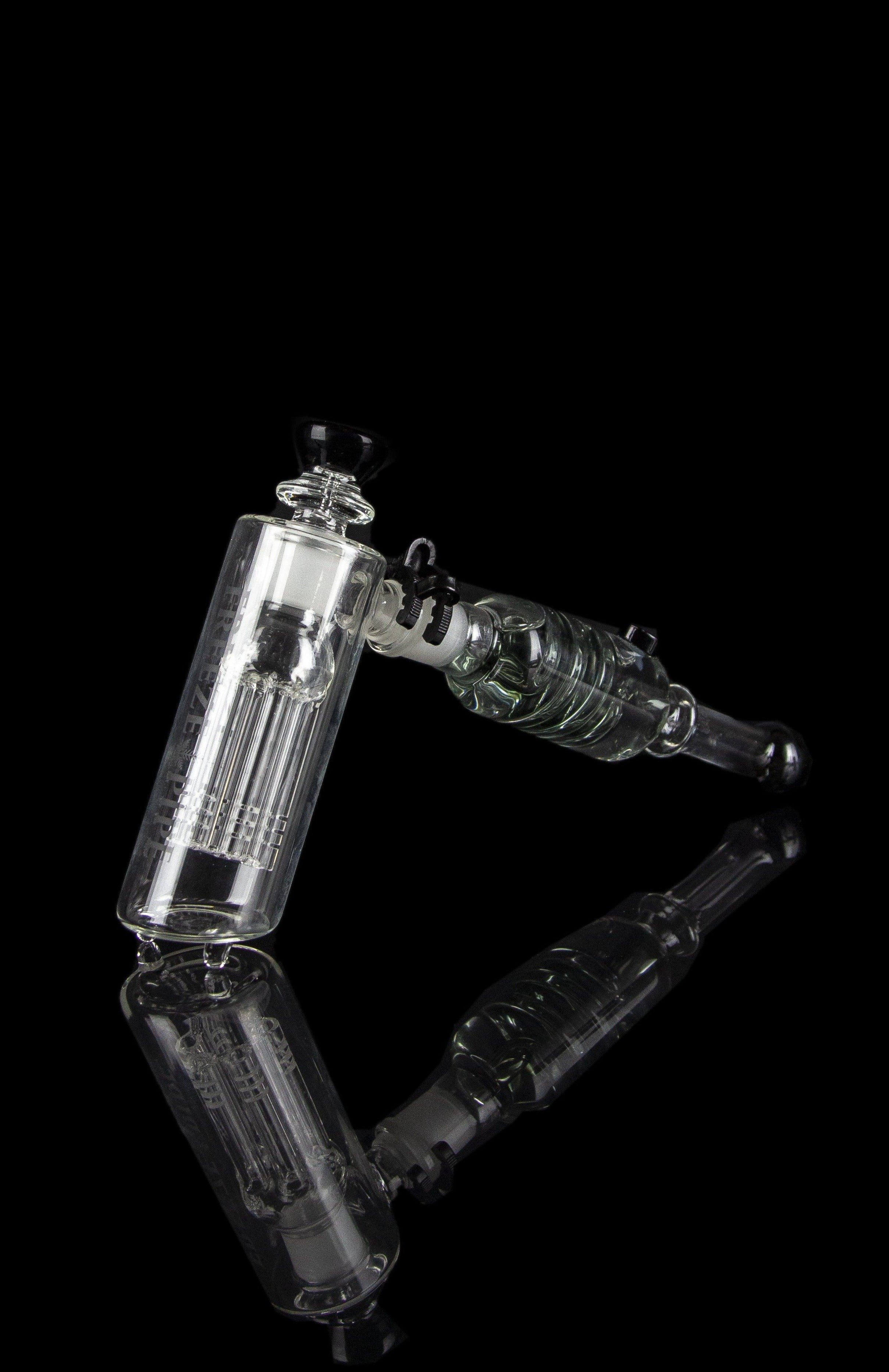 Clear glass water pipe (rig) with intricate percolators against a black background.