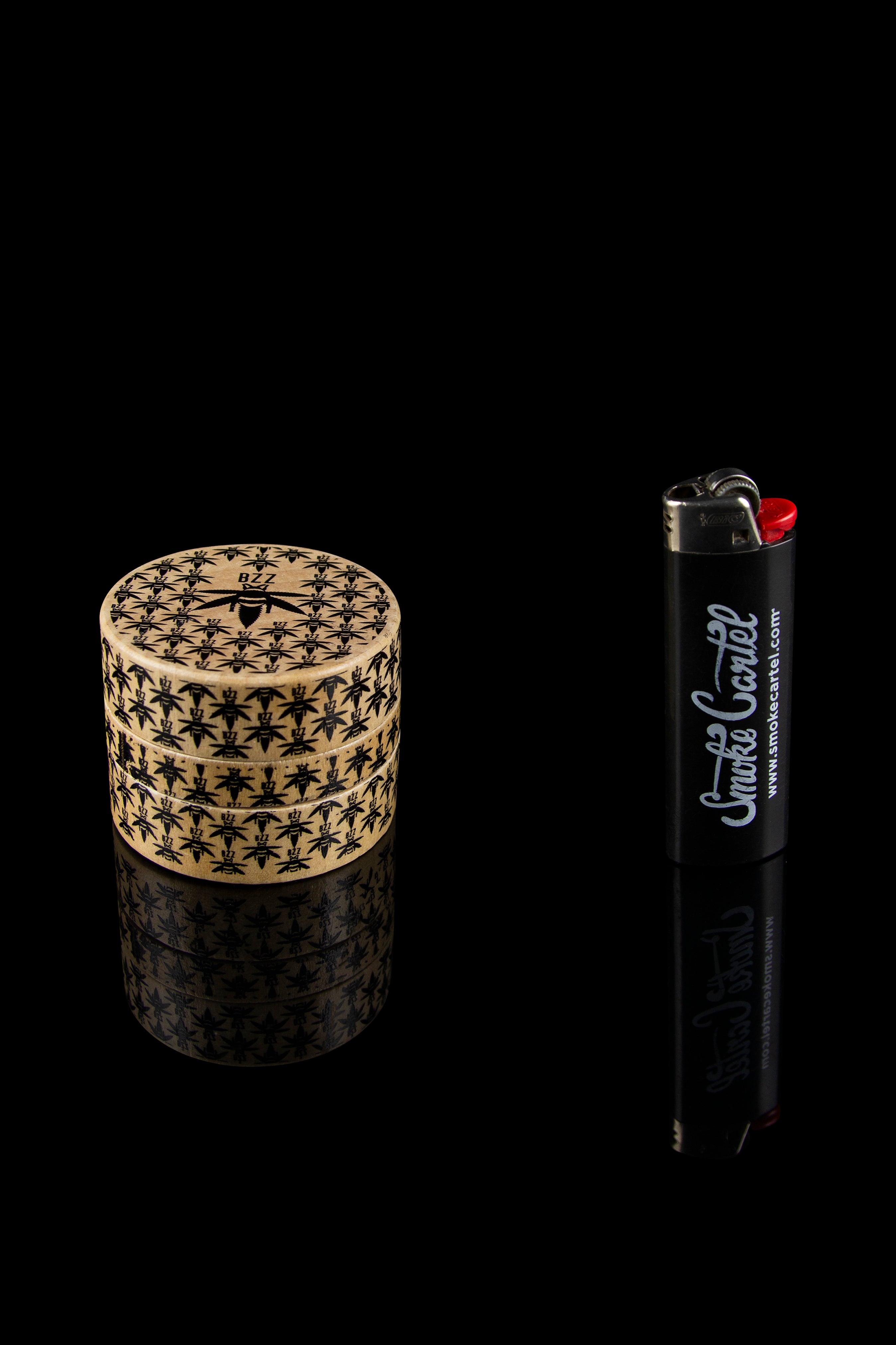 Cannabis storage jar with leaf pattern beside a black lighter branded with "Smoke Cartel".