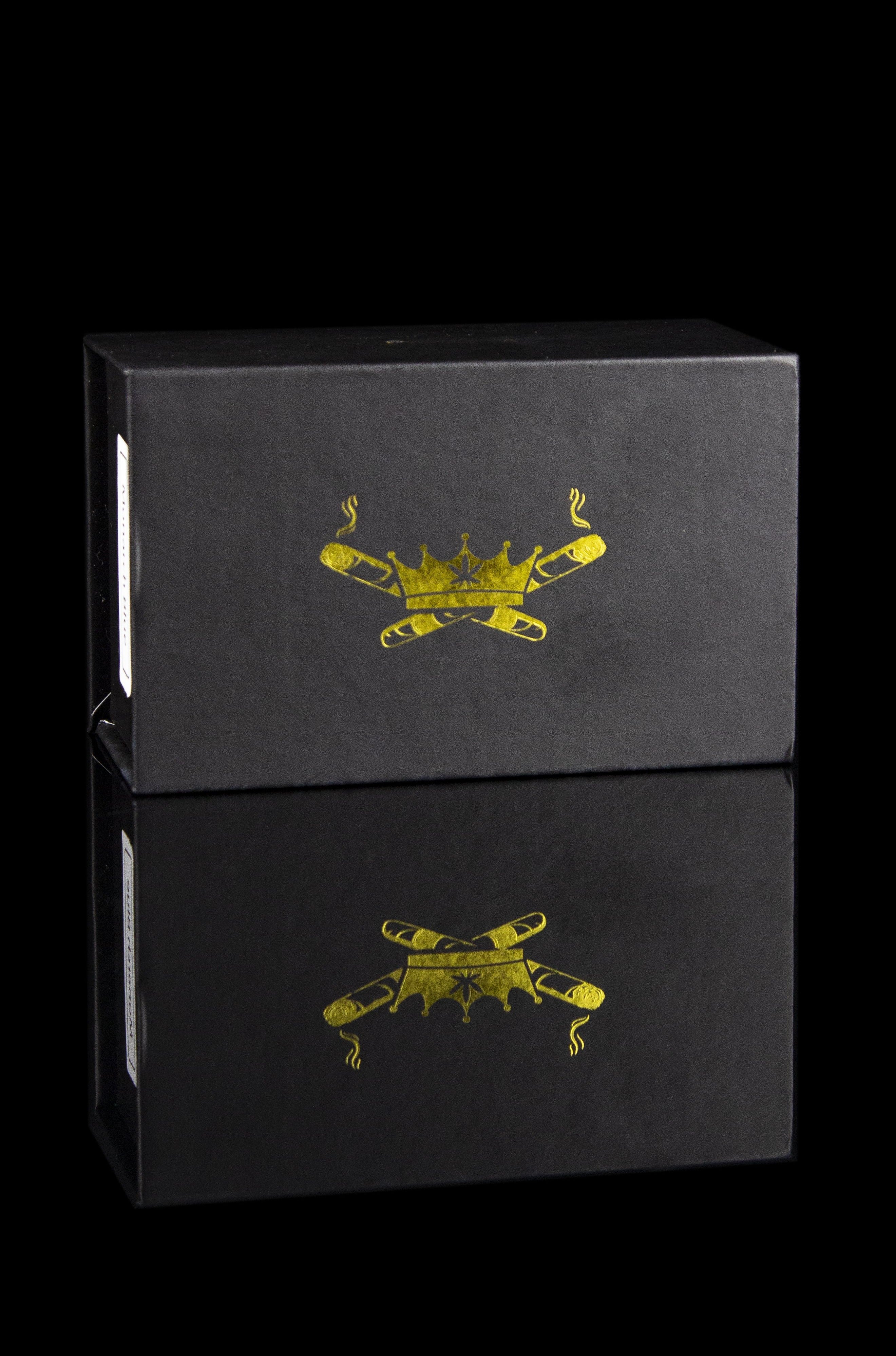 Two black boxes stacked, each embossed with a golden crossed-joint design and subtle smoke details.
