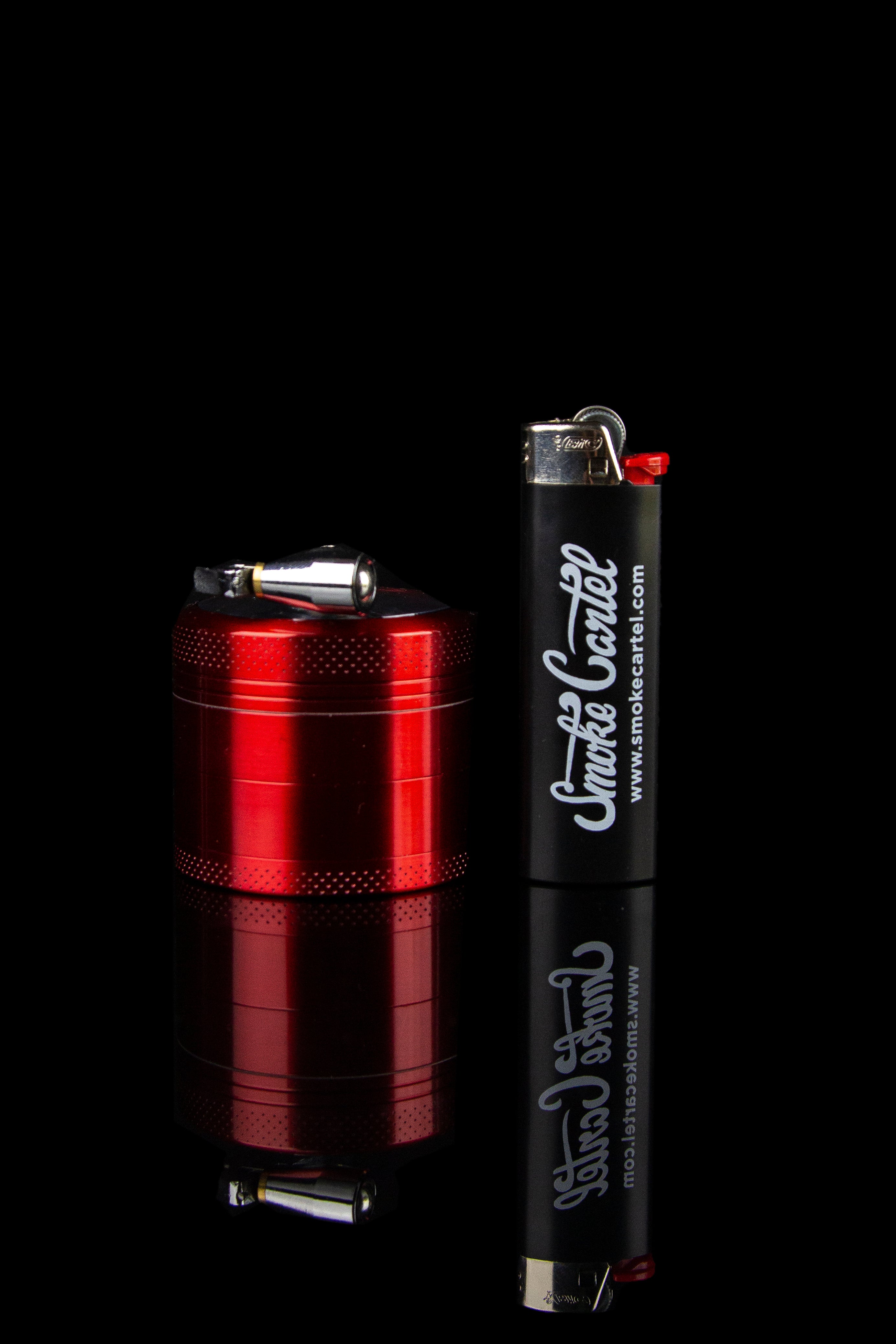 Black cannabis lighter with red accents and “Smoke Cartel” branding, reflecting on a glossy surface.