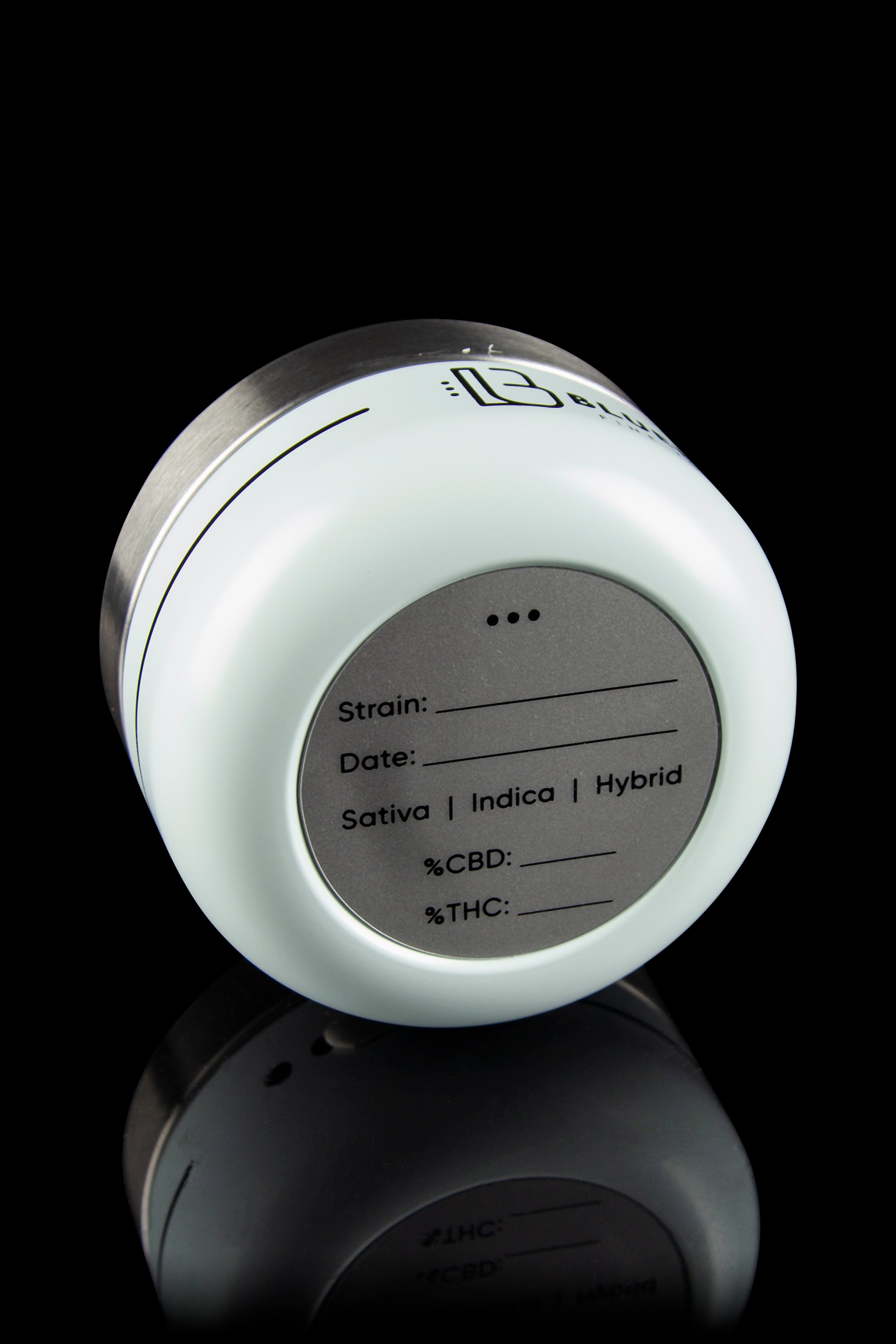 White cannabis storage jar with fill-in fields for strain, date, and THC/CBD percentages, reflecting on a dark surface.