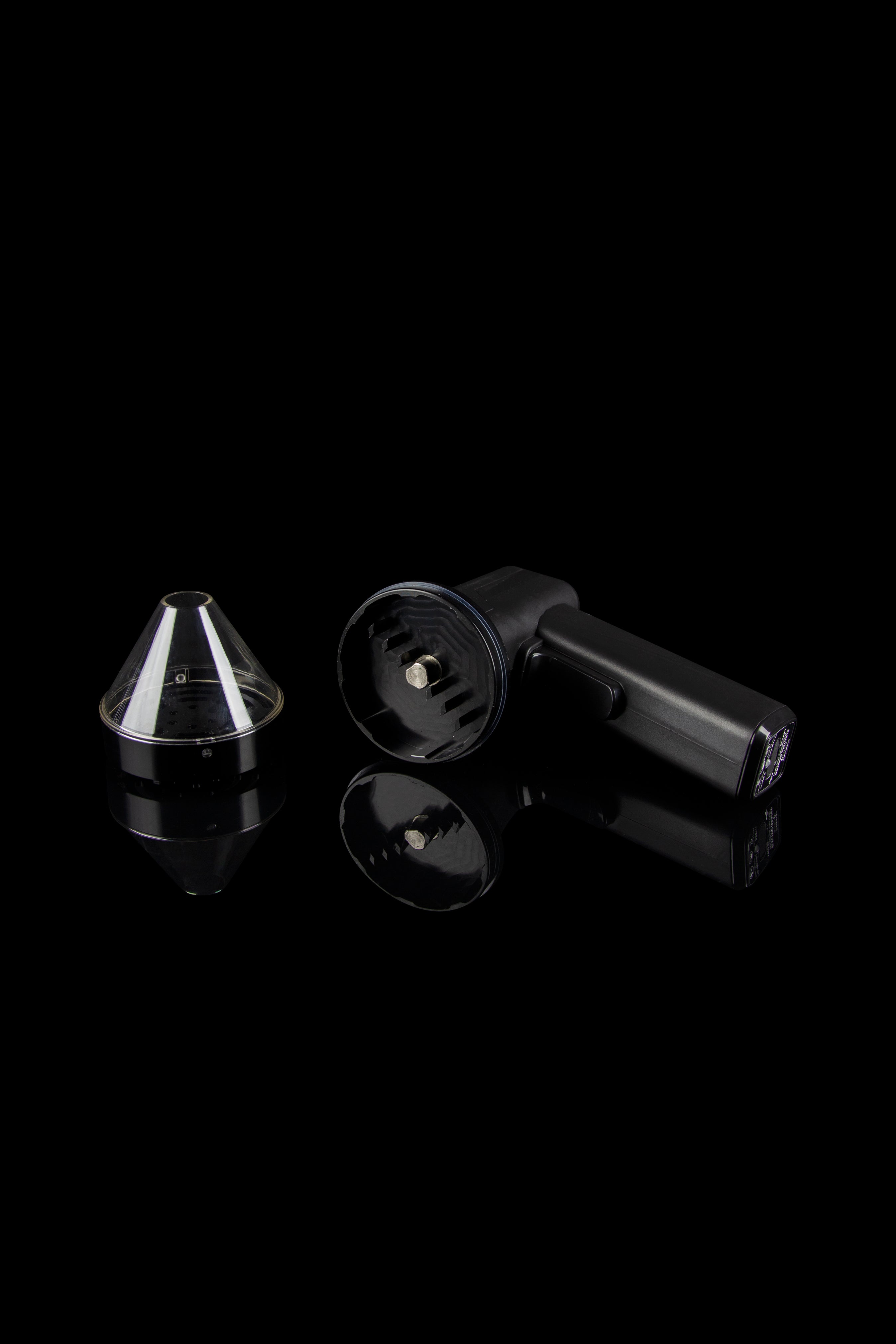 Black cannabis vaporizer components displayed on a reflective surface.