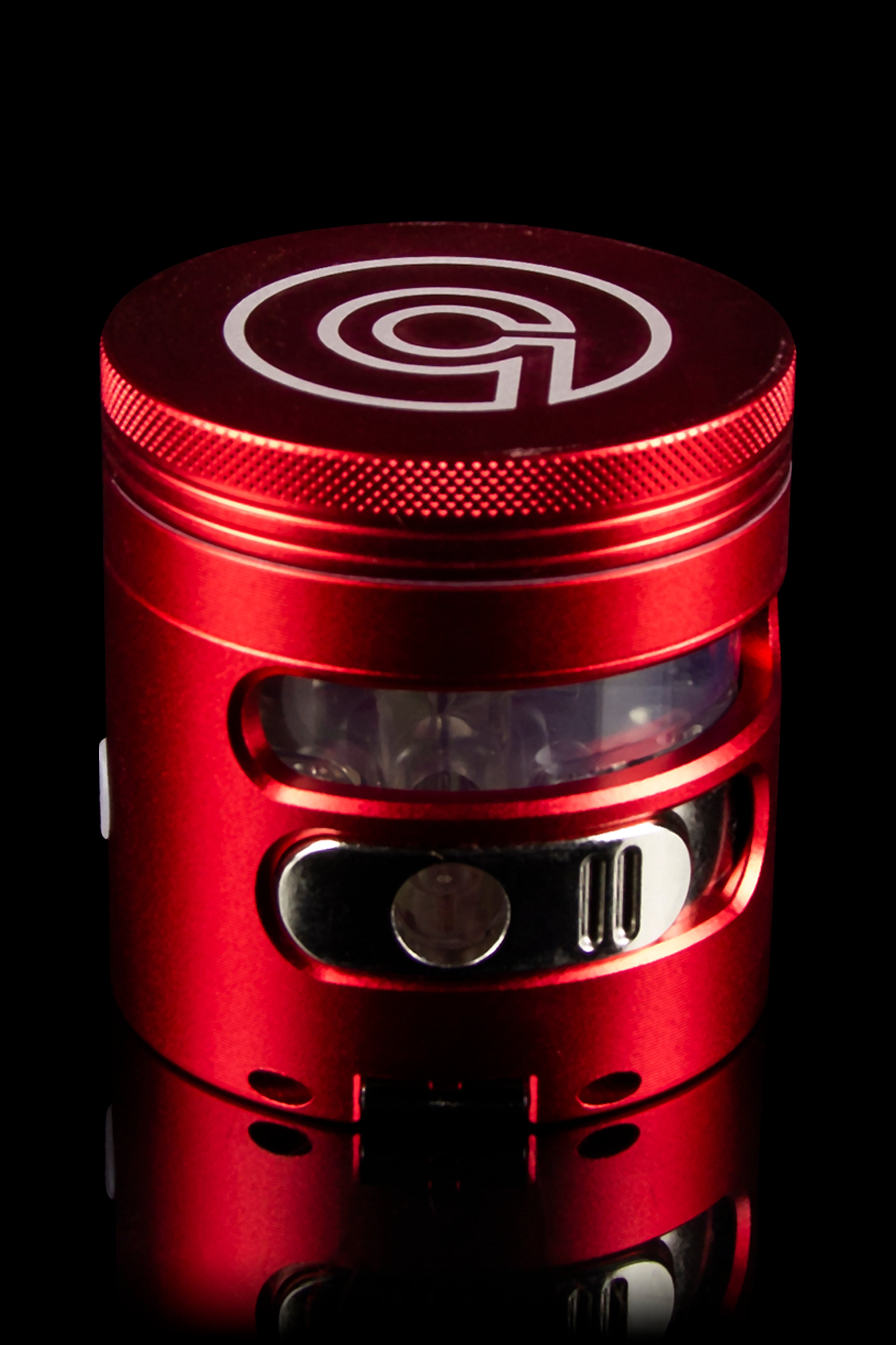 Red cannabis grinder with a clear viewing window, showcasing a metallic interior.