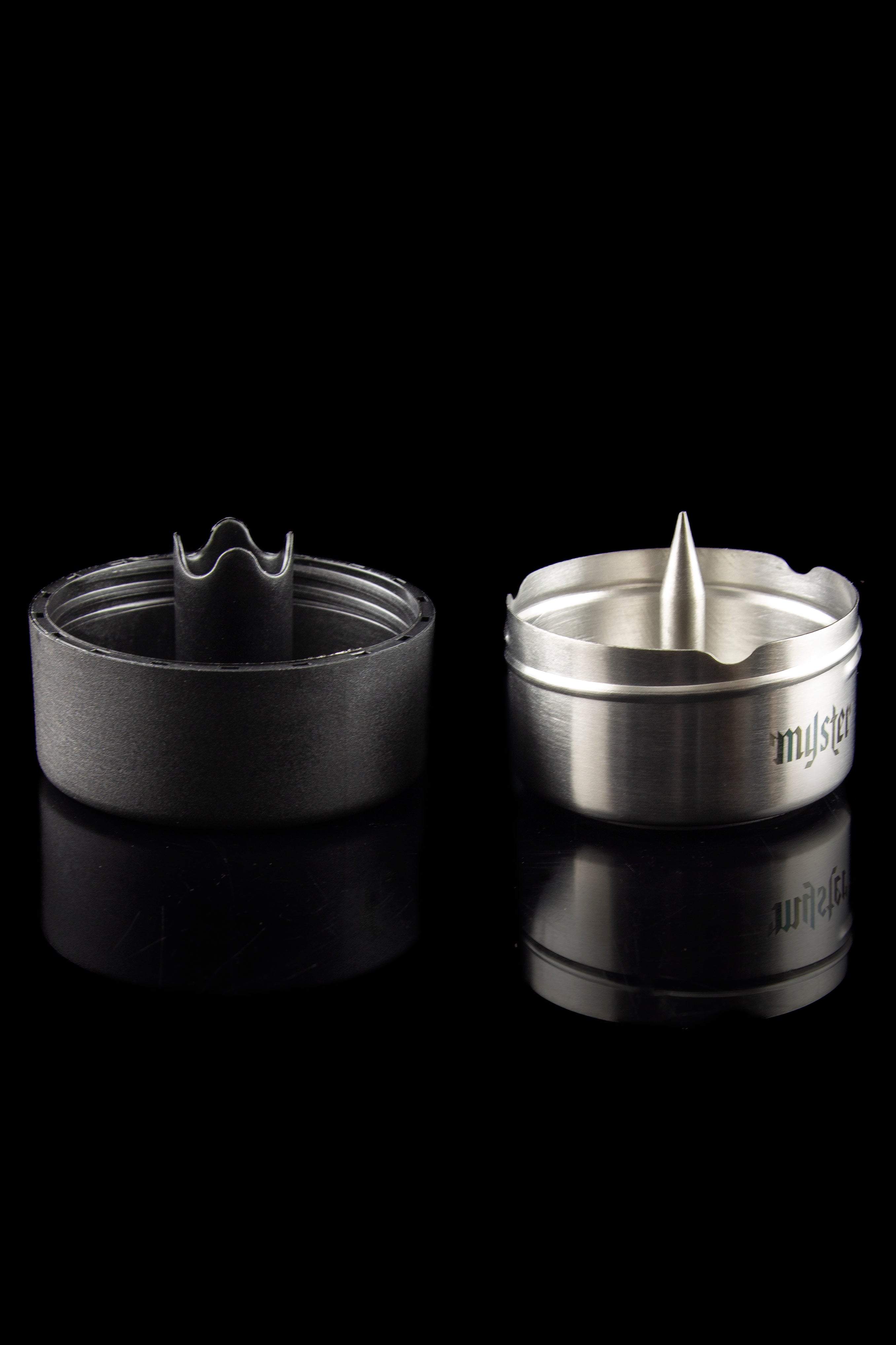 Silver cannabis smoking bowl with a spiked interior and removable screen, reflected on a dark surface.