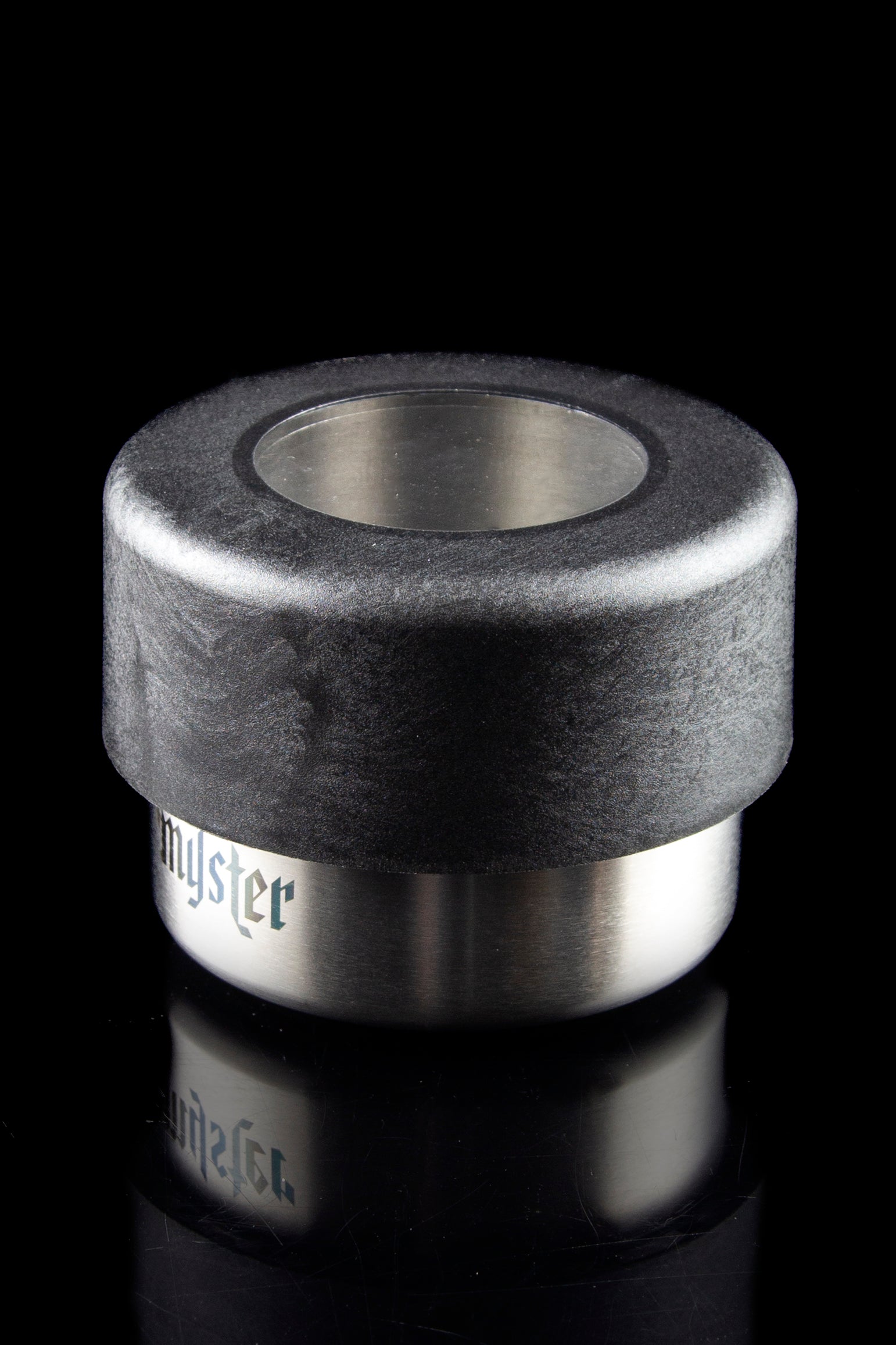 Sleek, cylindrical cannabis concentrate container with a black textured top and mirrored stainless steel base labeled "myster."