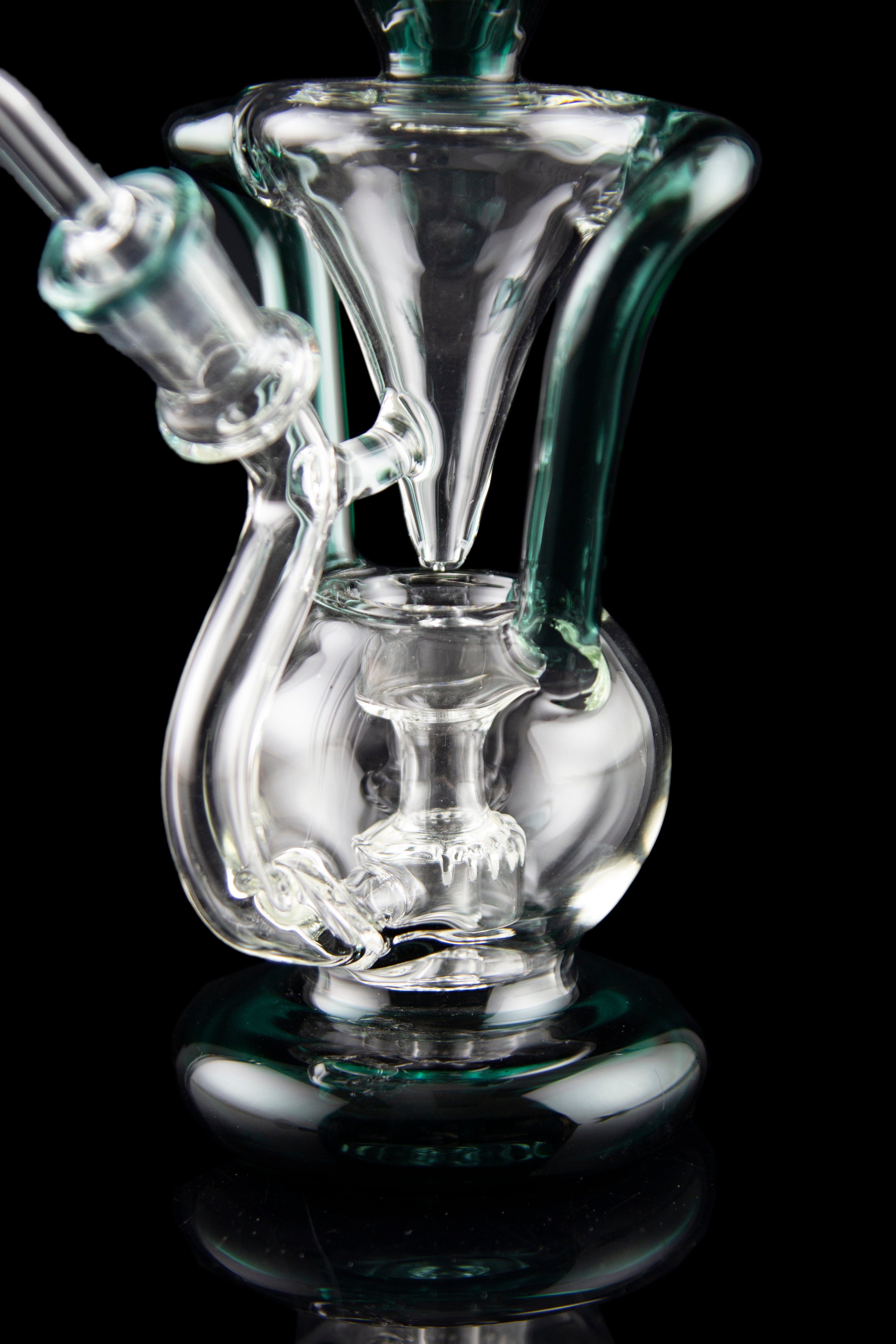 Clear glass water pipe (rig) with intricate bubbler design, isolated on black.
