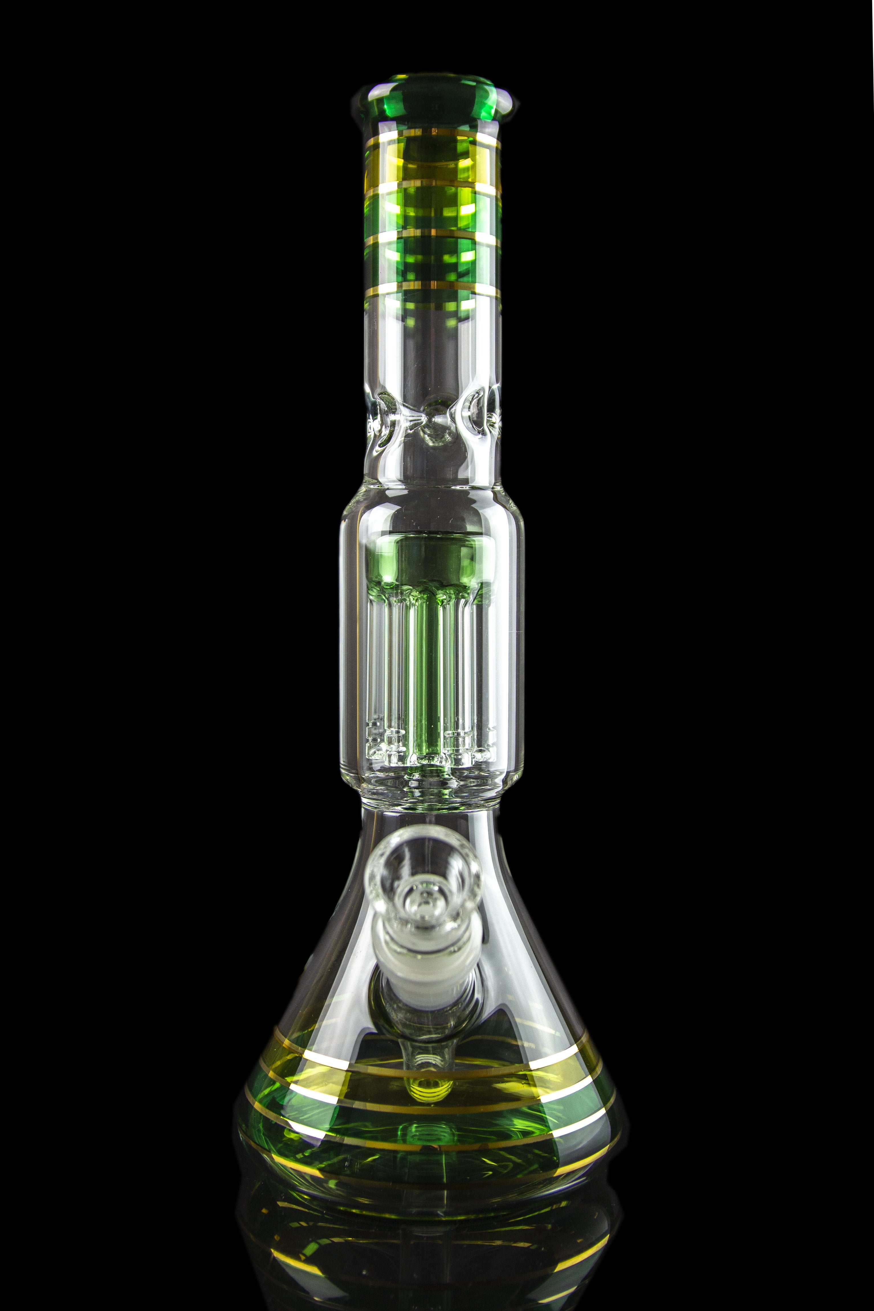 Glass water pipe (bong) with intricate percolators and green accents, isolated on a black background.