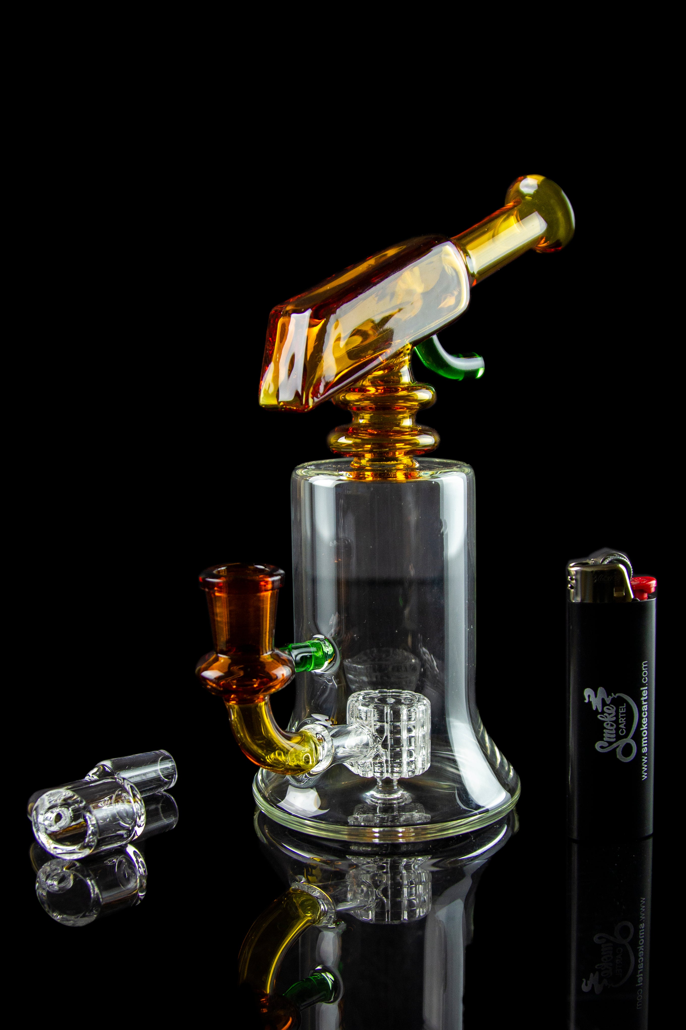 A vibrant glass water pipe (bong) with orange and green accents, displayed with accompanying glass marbles on a reflective surface.