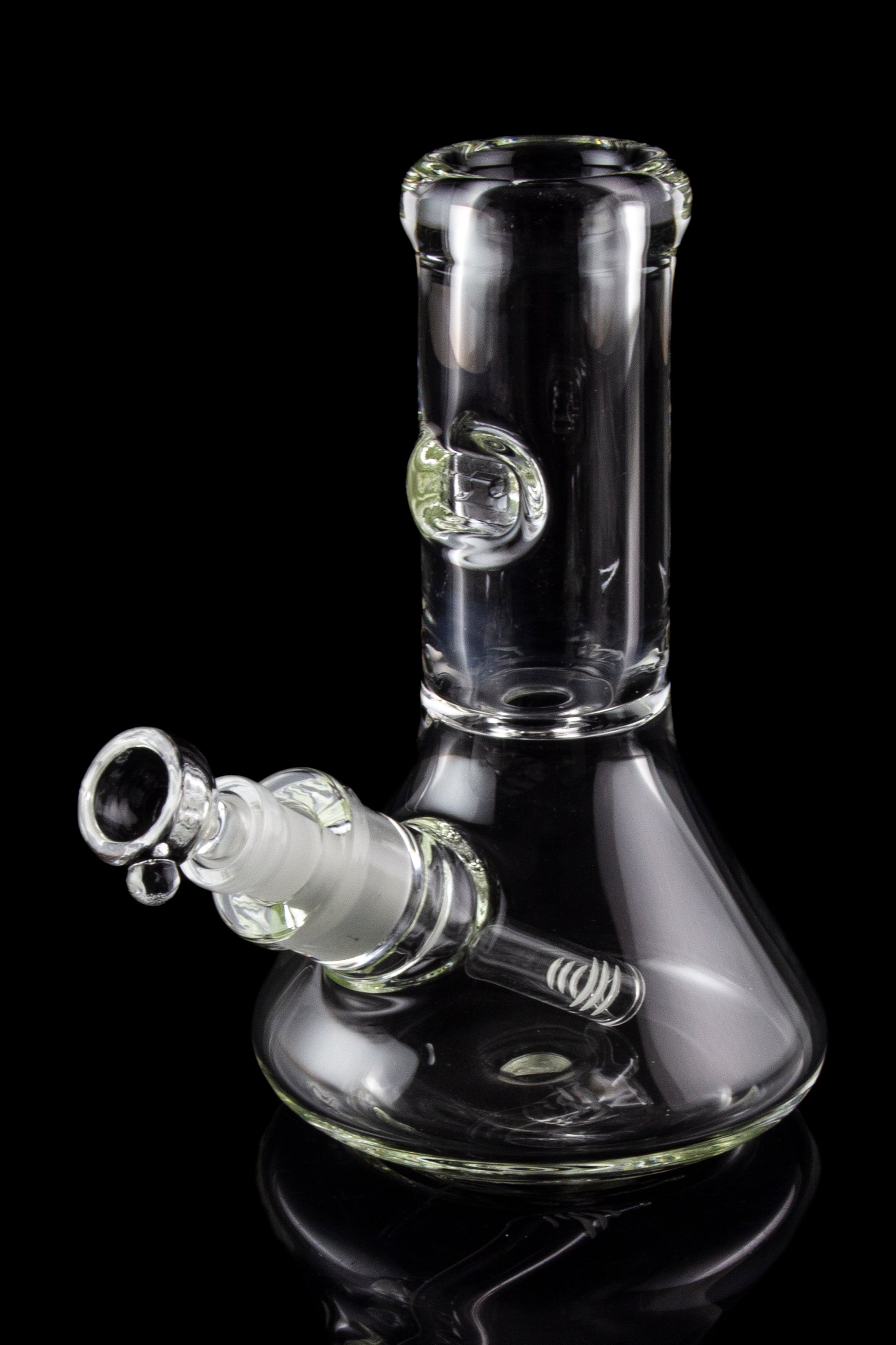 Clear glass bong with ice catcher, reflecting on a black surface.