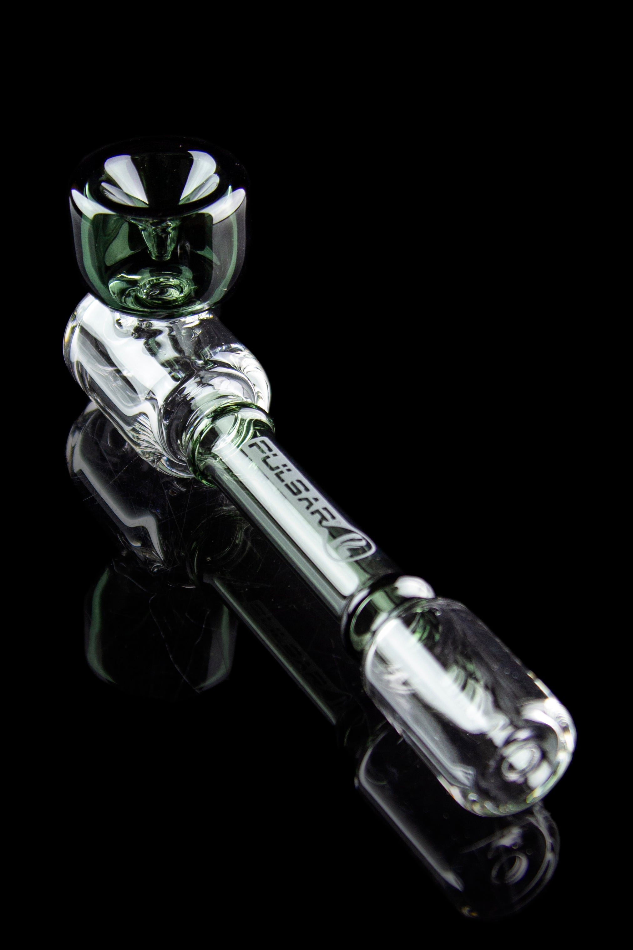 Clear glass cannabis oil rig with green accents, displayed on a reflective black surface.