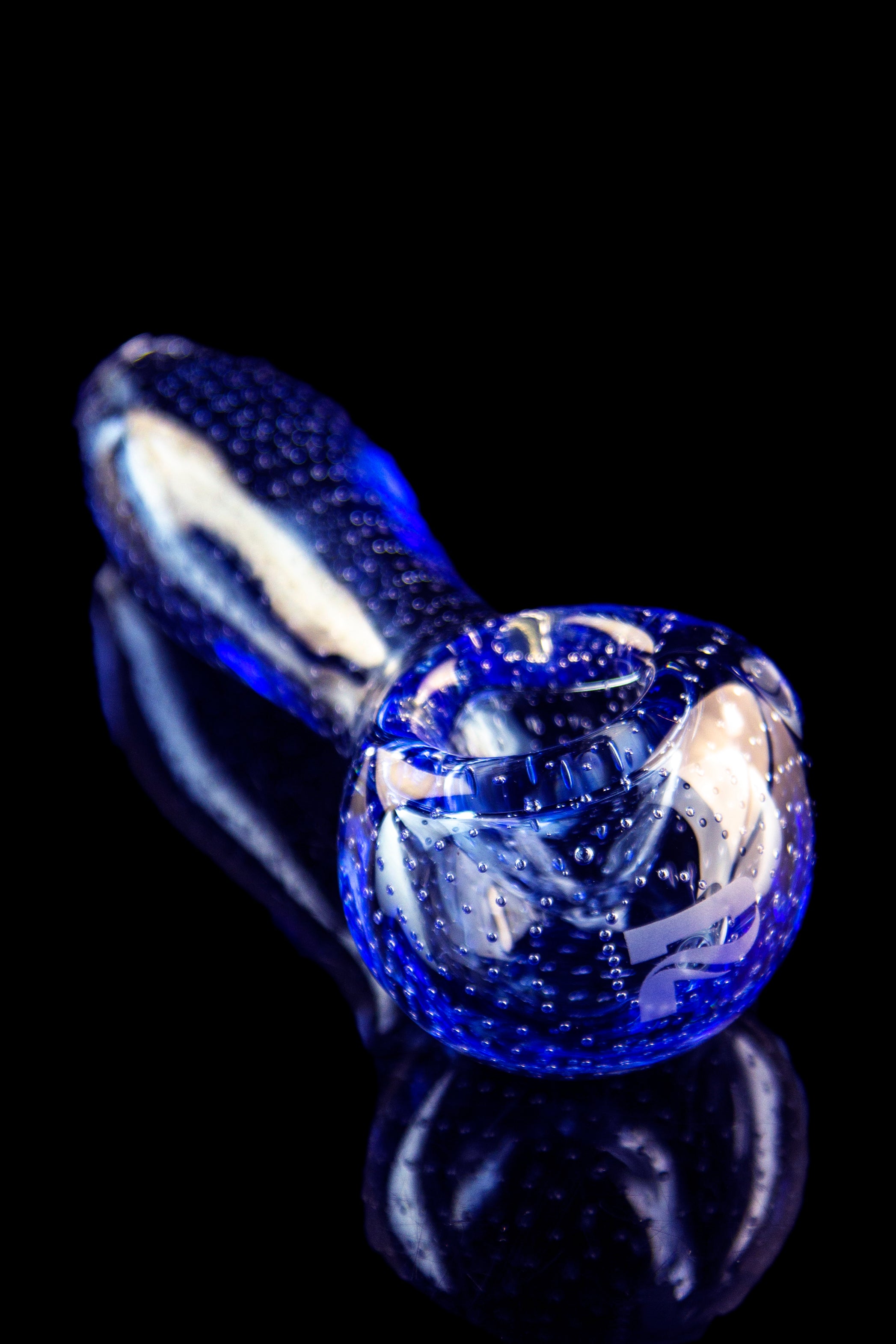 Blue glass pipe with bubbling texture, studio shot.