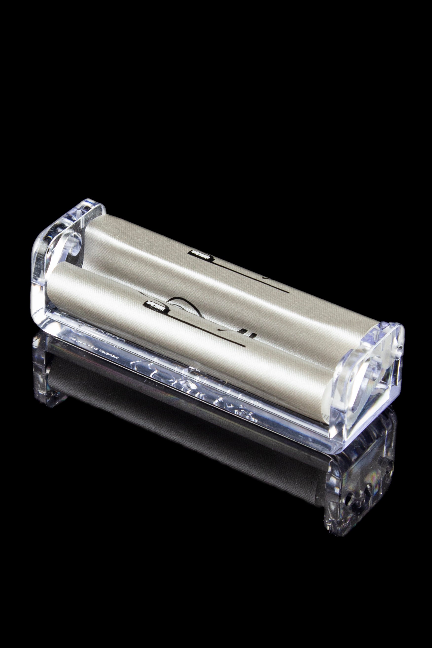 Clear acrylic rolling machine for making cigarettes, isolated on a black background.