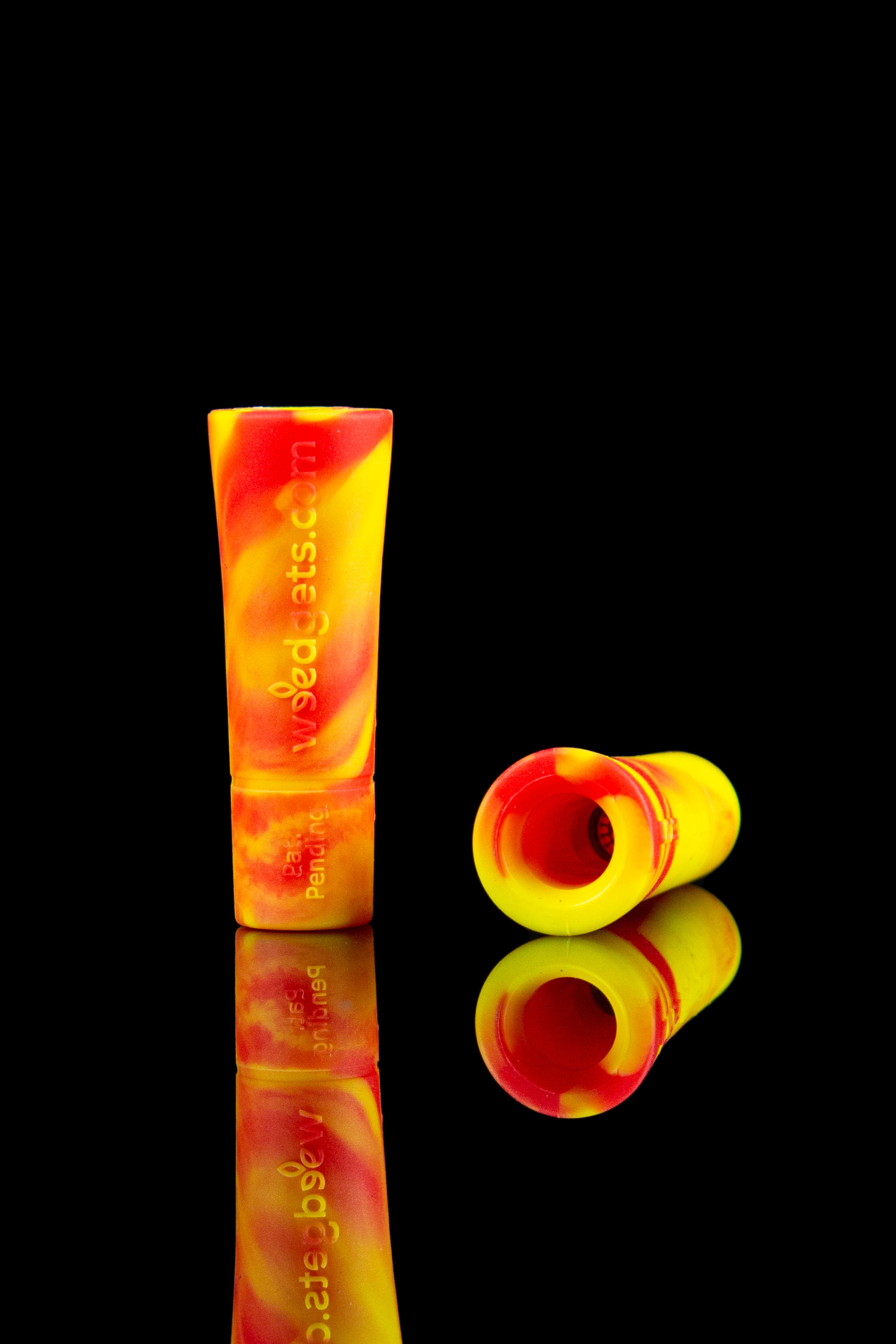 Red and white silicone cannabis pipe tips with reflective surface.