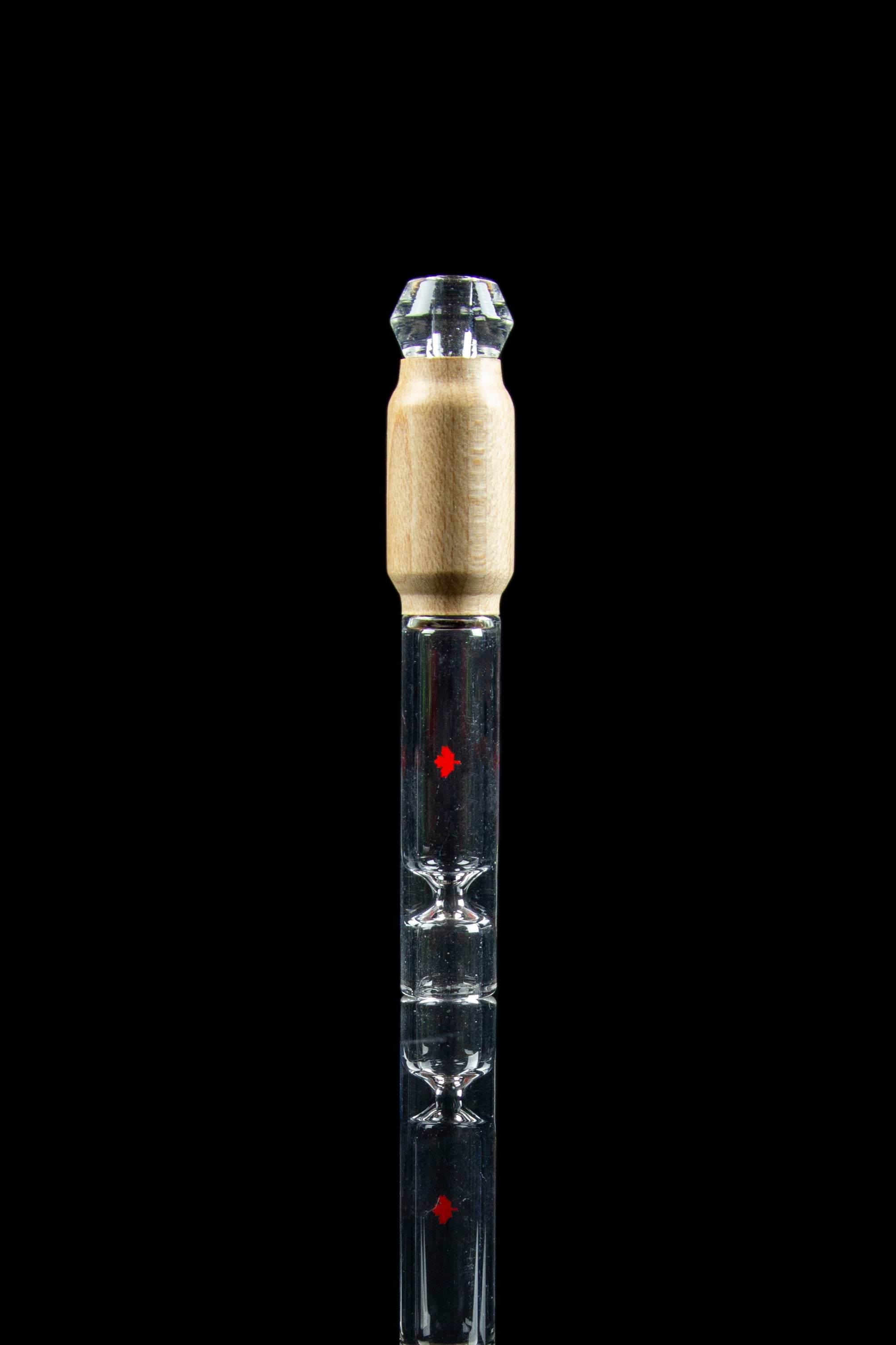 Clear glass cannabis oil burner pipe with gold accents and red detailing, isolated on black.