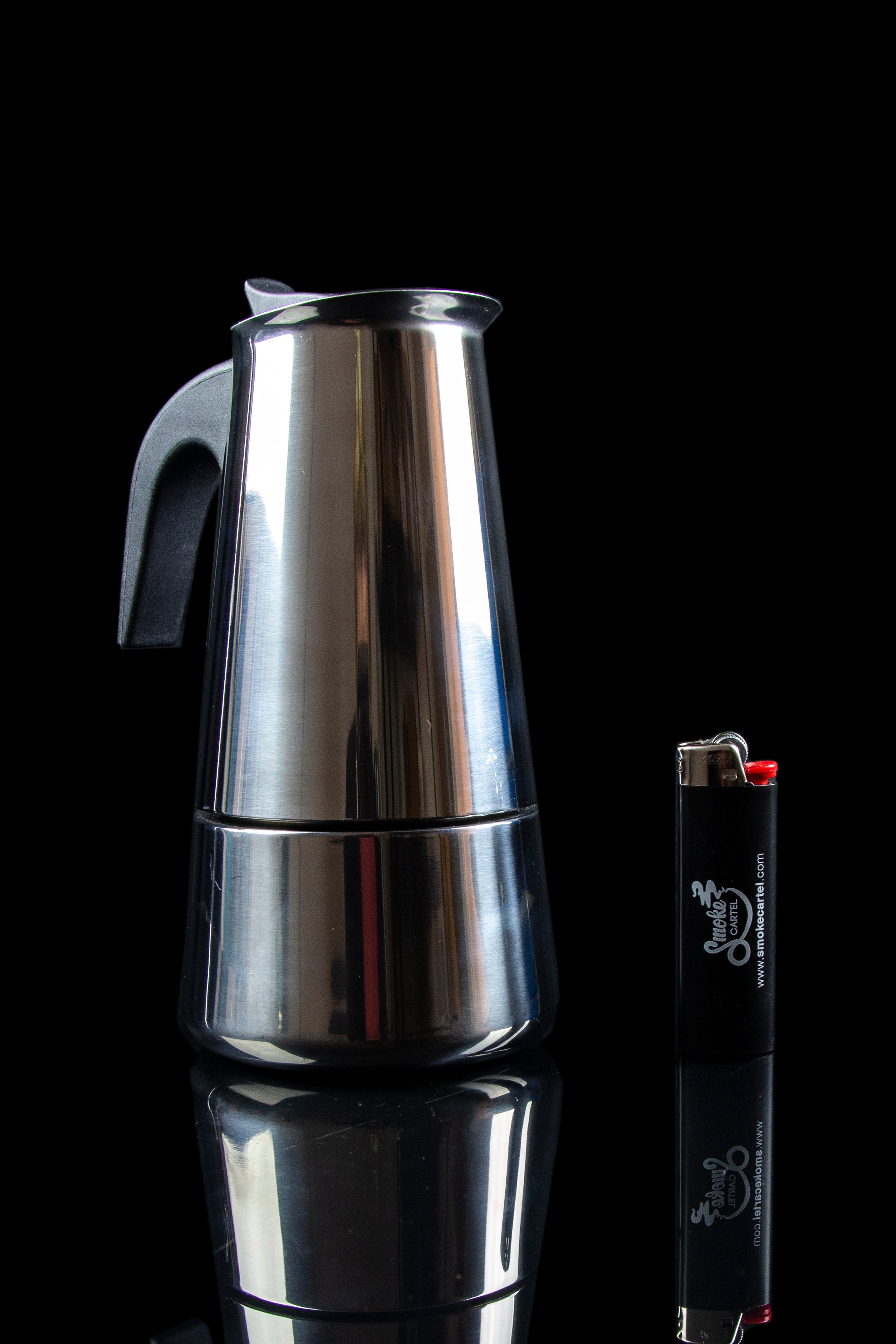 Silver grinder and black lighter against a dark background.