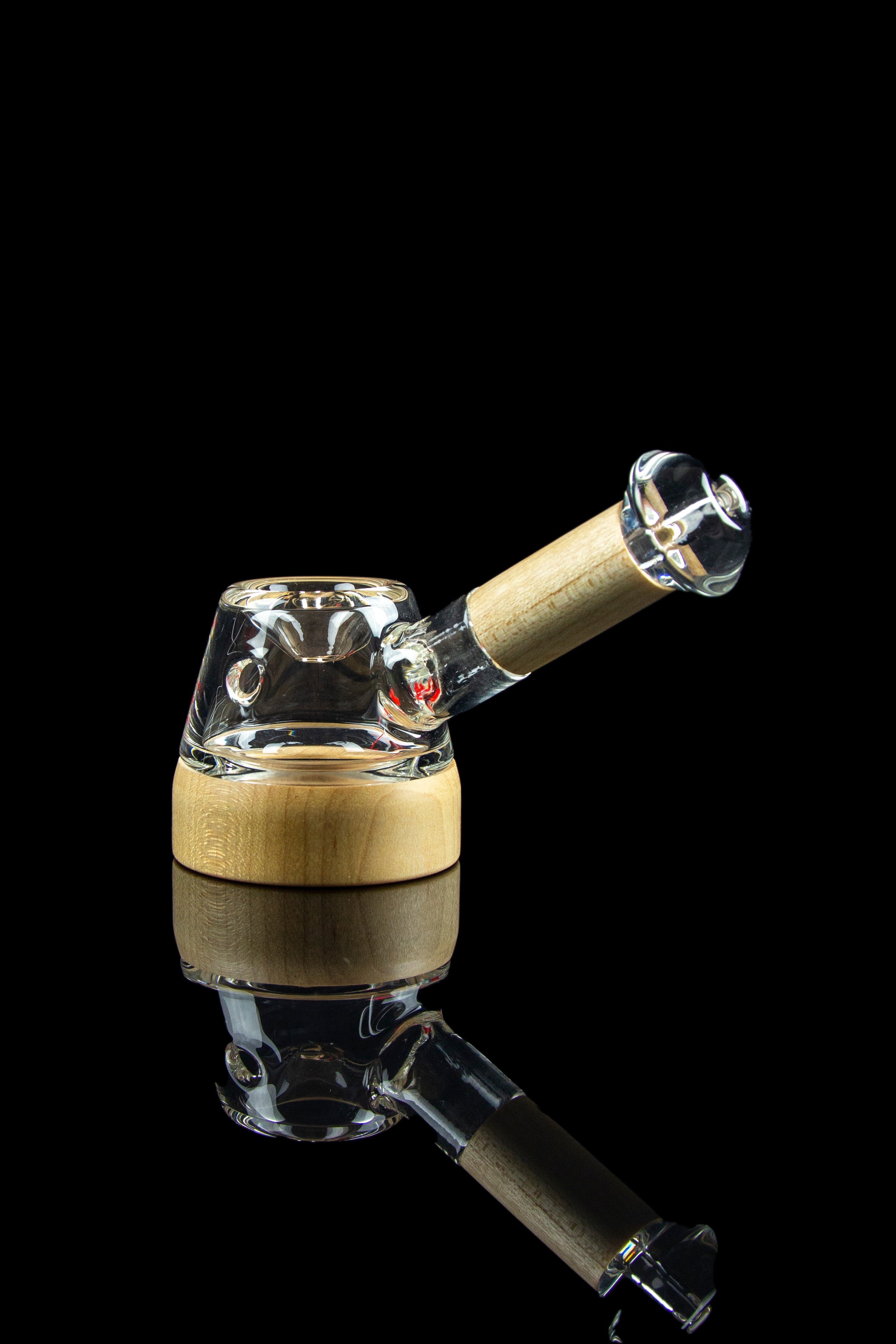 Glass cannabis water pipe with a wooden accent and reflective surface.