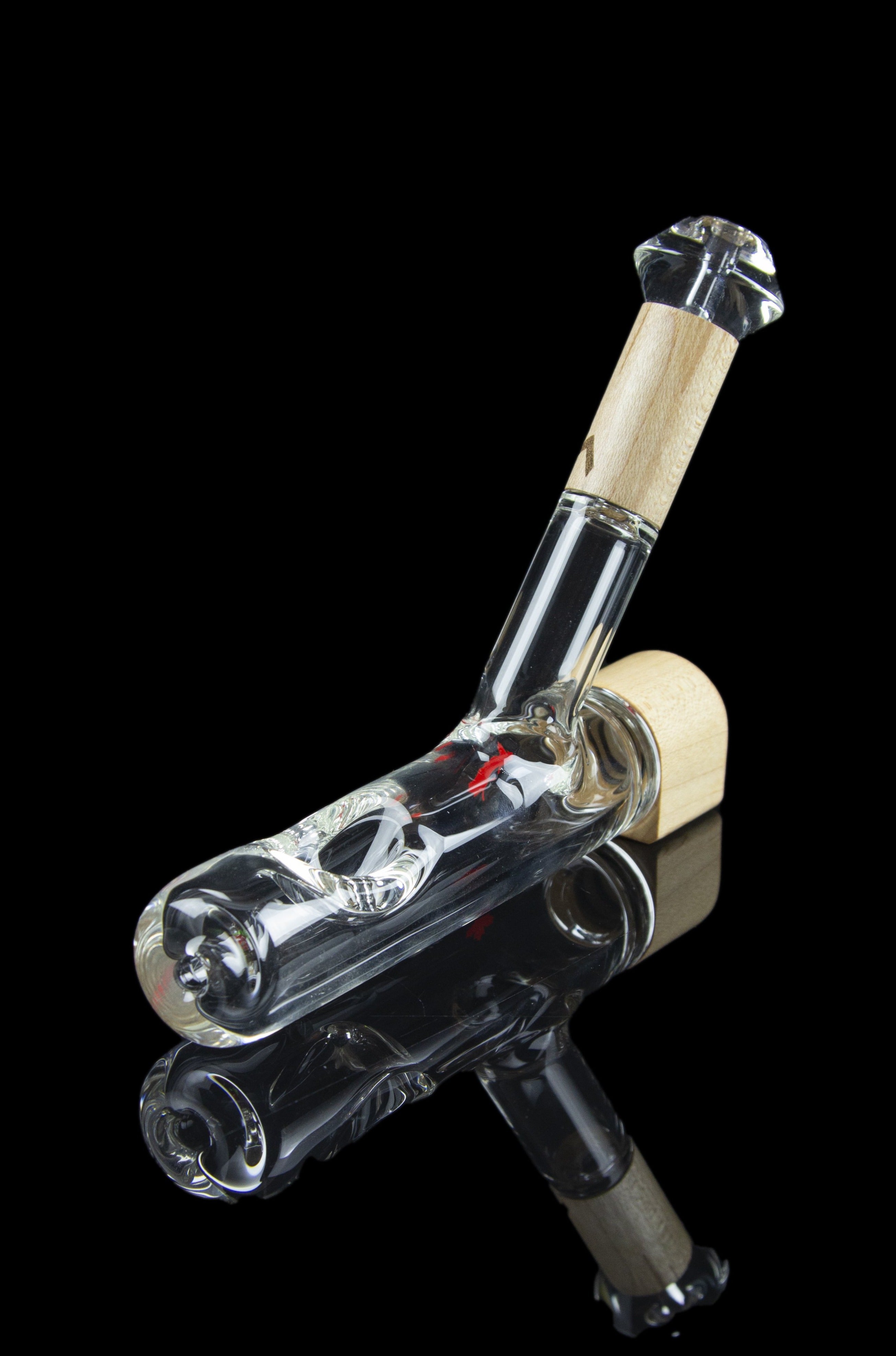 Glass bubbler pipe with intricate white and gray swirls, reflecting on a dark surface.