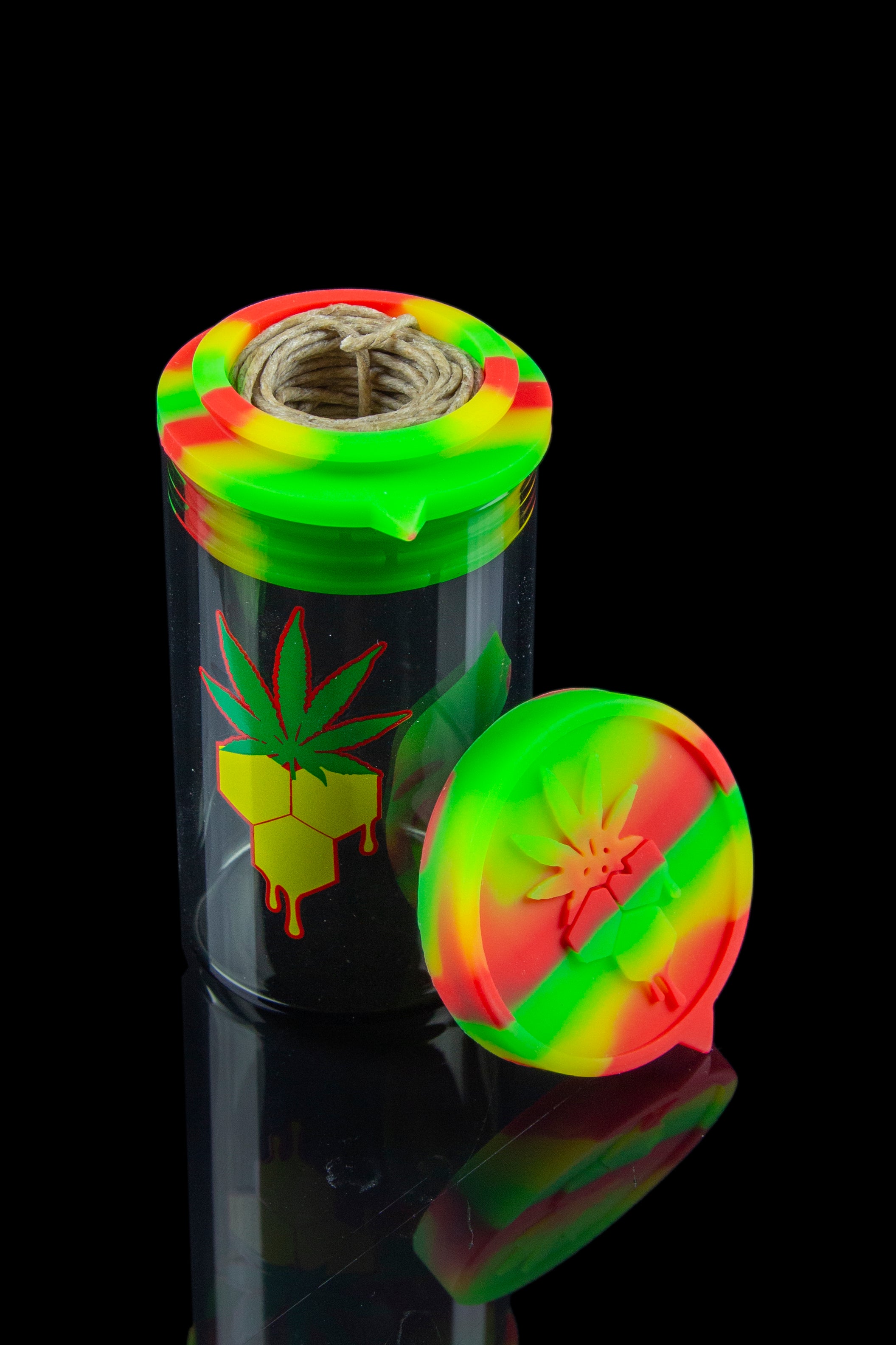 Colorful silicone smoking jar with a cannabis leaf design and pre-rolled joint inside, displayed on a reflective black surface.