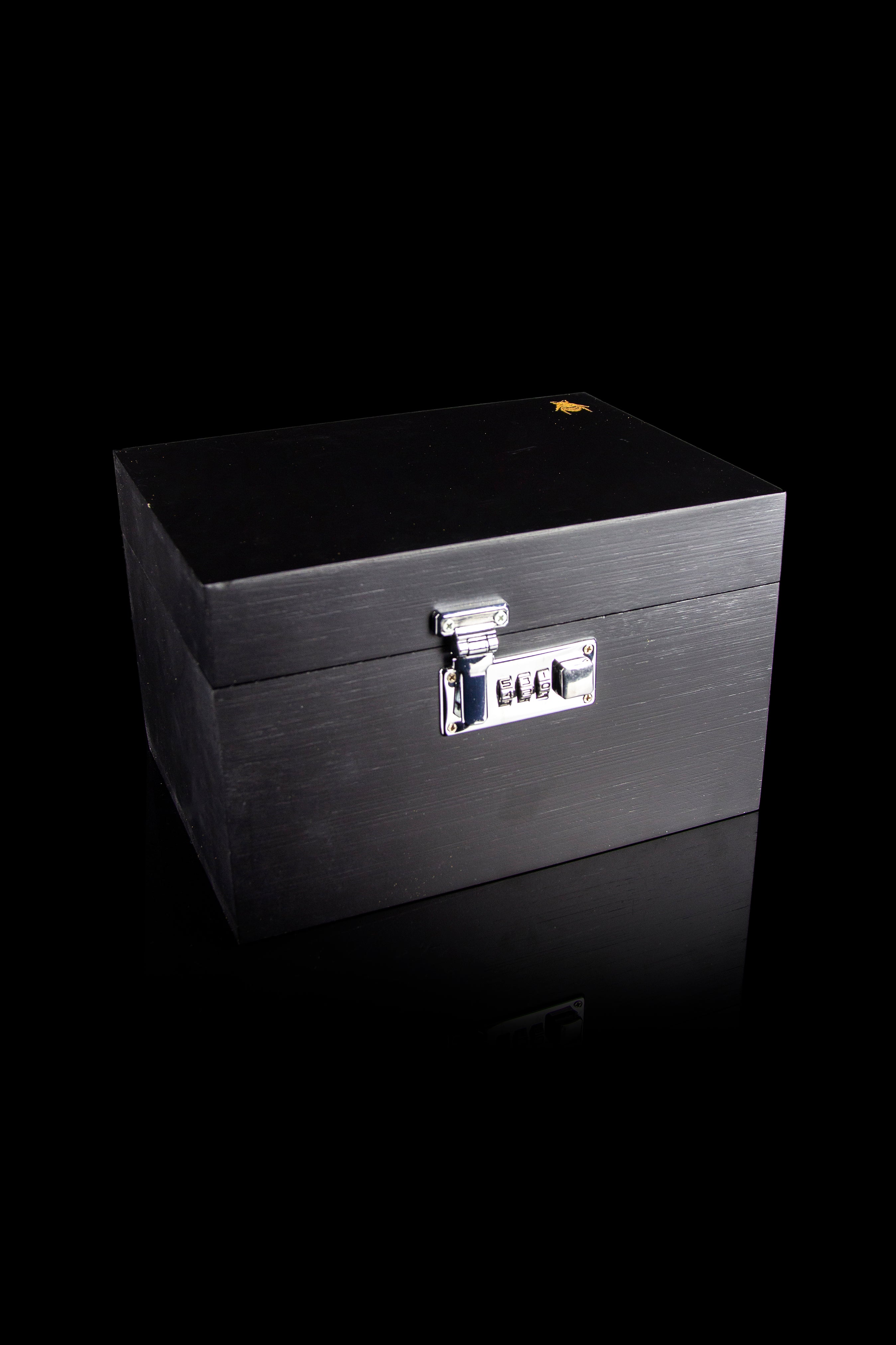 Black cannabis storage box with combination lock, isolated on a black reflective surface.