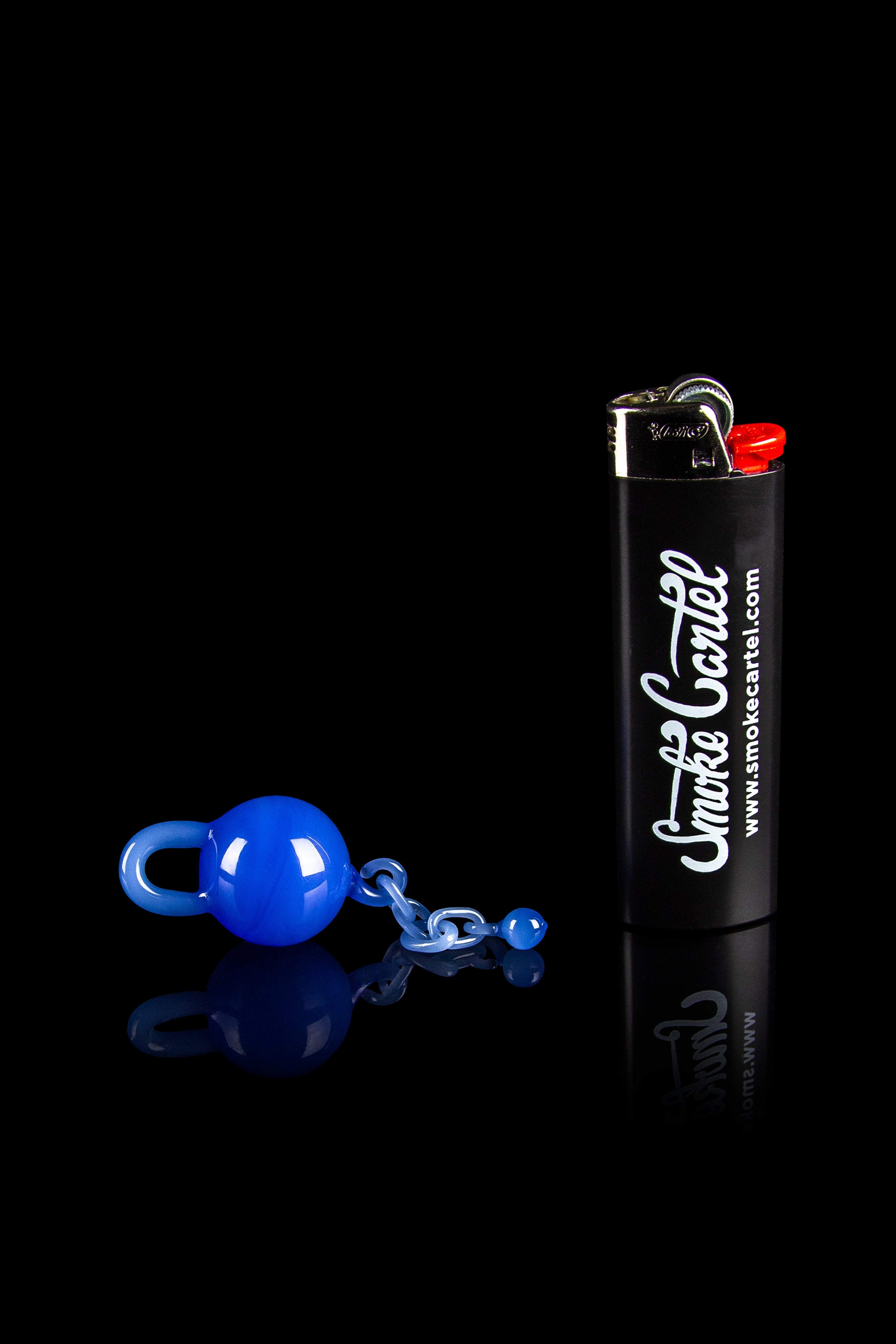 Blue glass cannabis accessories and a branded lighter against a black reflective surface.