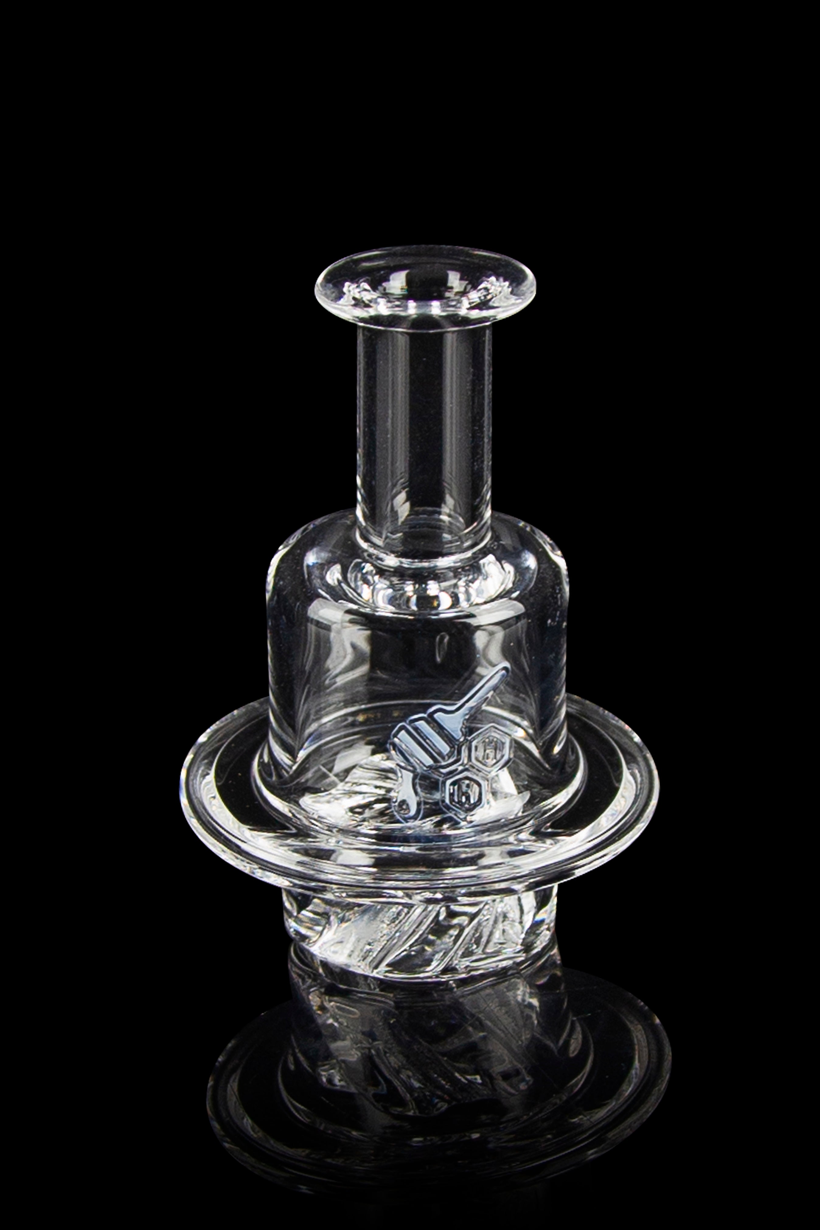 Clear glass dab rig with intricate sculpting, isolated on a black background.