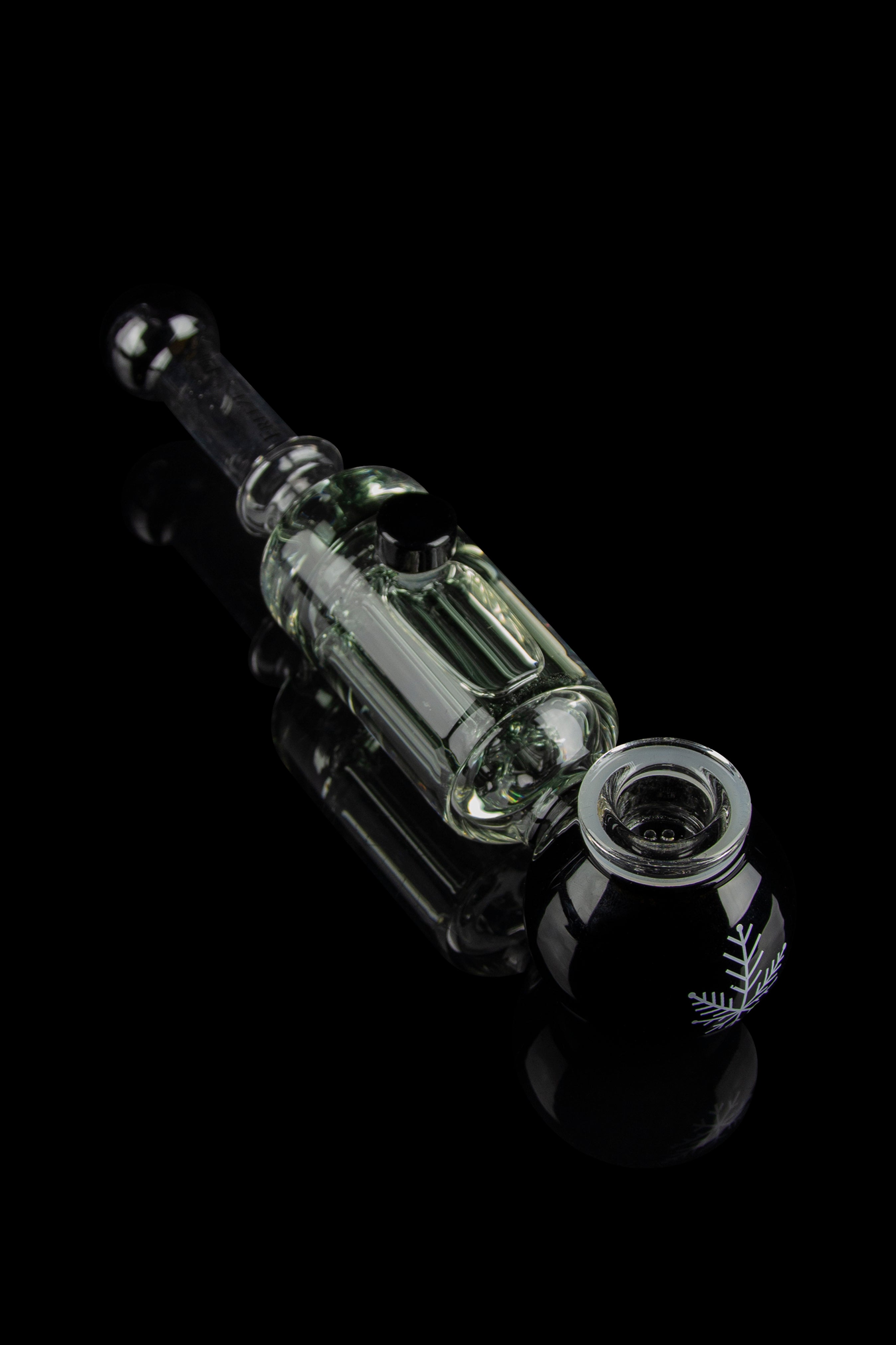 Clear glass oil rig with intricate design against a black background.