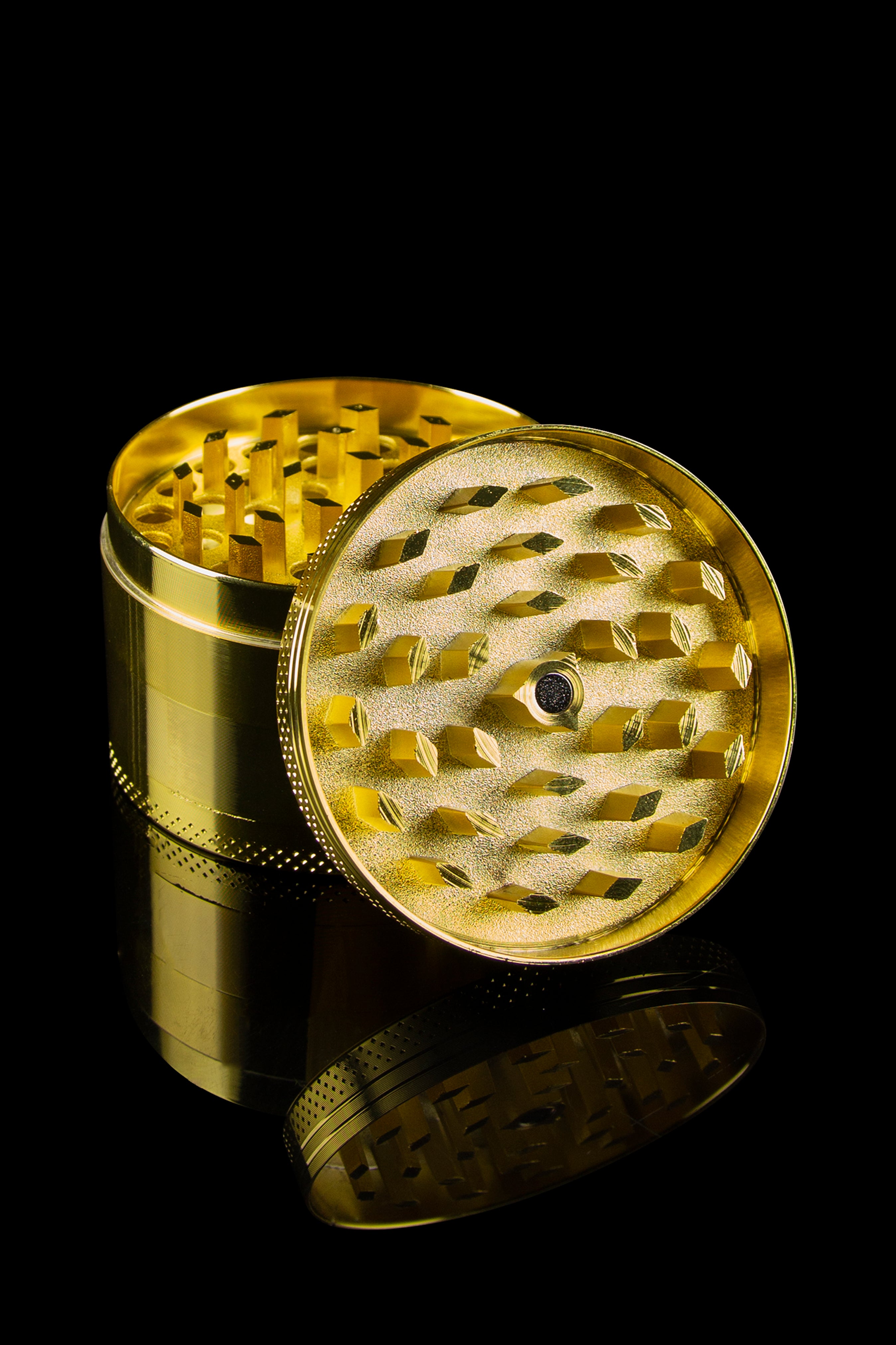 Gold cannabis grinder with lid open, revealing the internal grinding mechanism, on a black background.