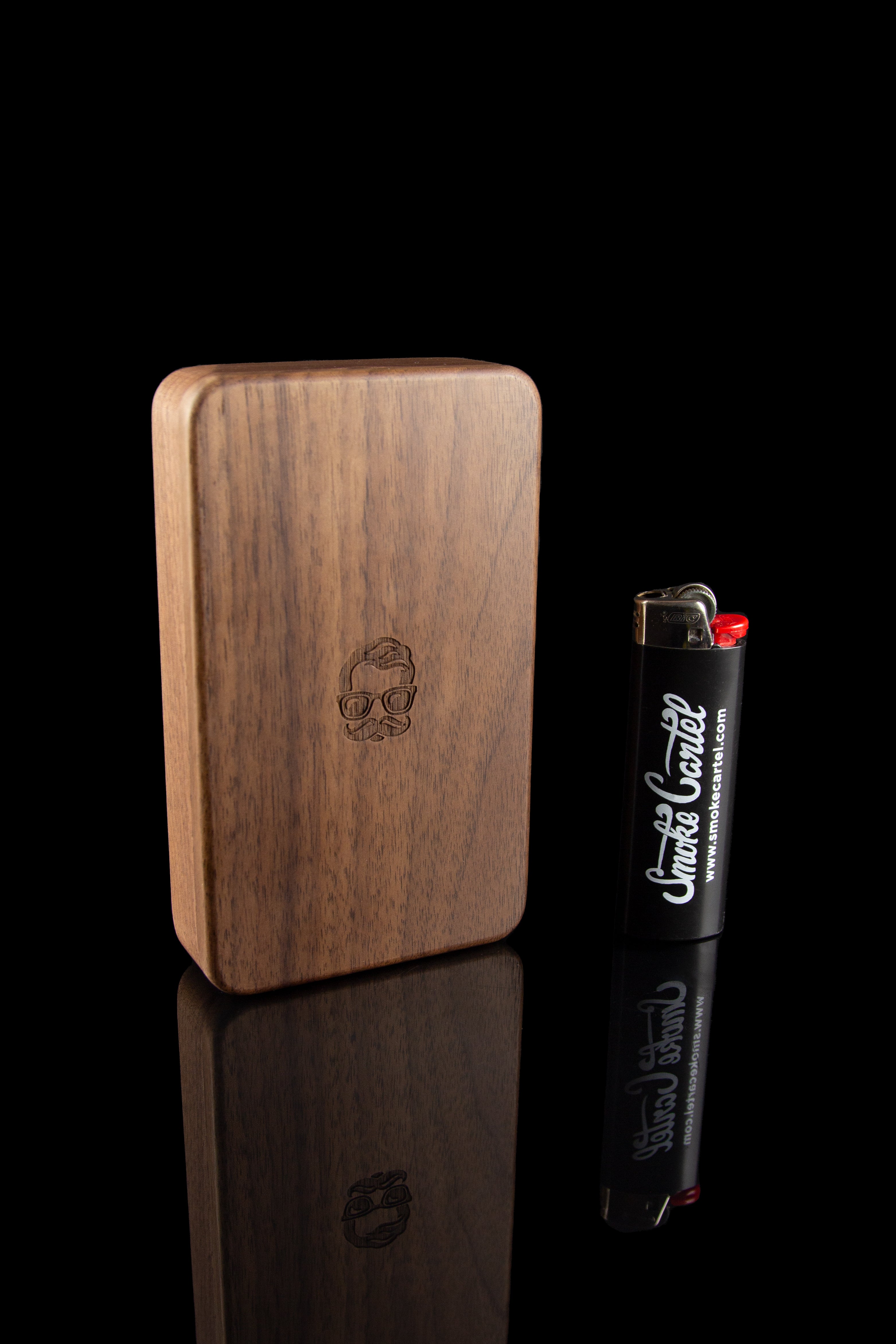Wooden dugout with a branded lighter, reflecting on a glossy black surface.