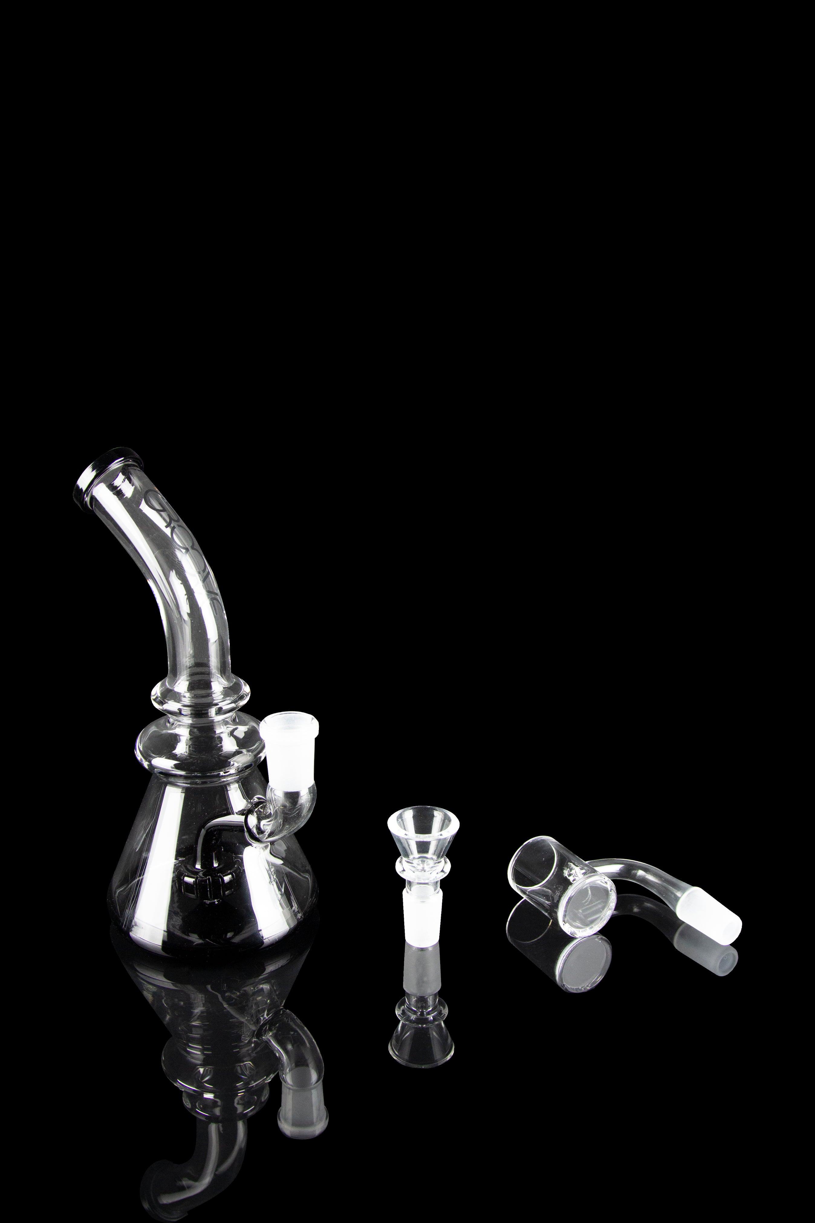 Clear glass dab rig with accessories on a black background.