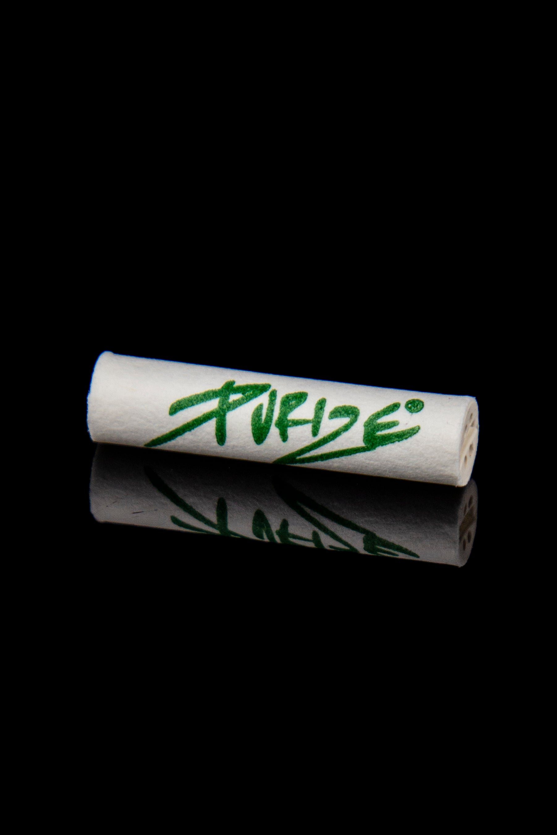 Rolled cannabis filter tips with green “Pure” logo reflected on a dark surface.