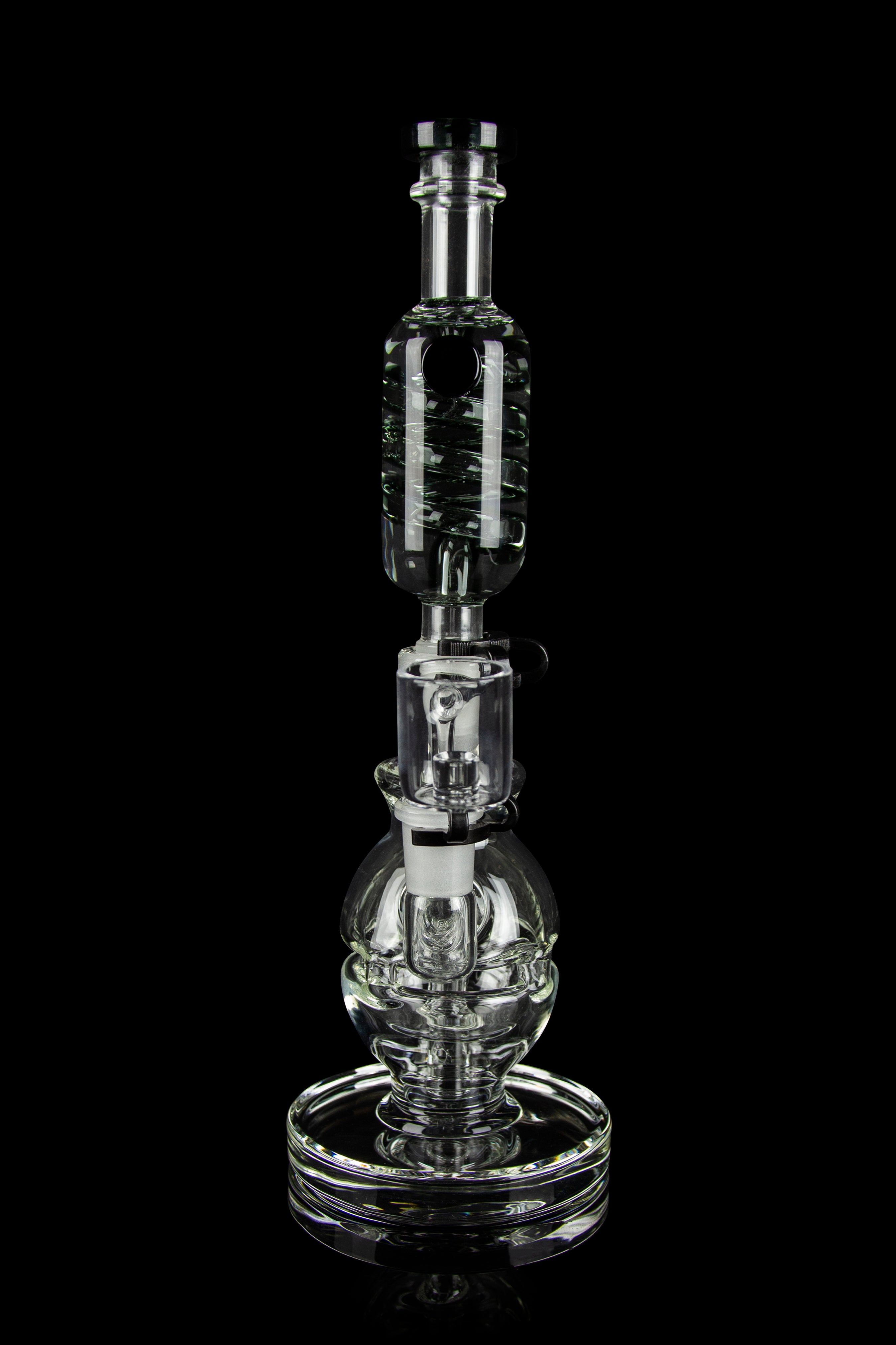 Clear glass water pipe (rig) with intricate bubbler design, isolated on black.