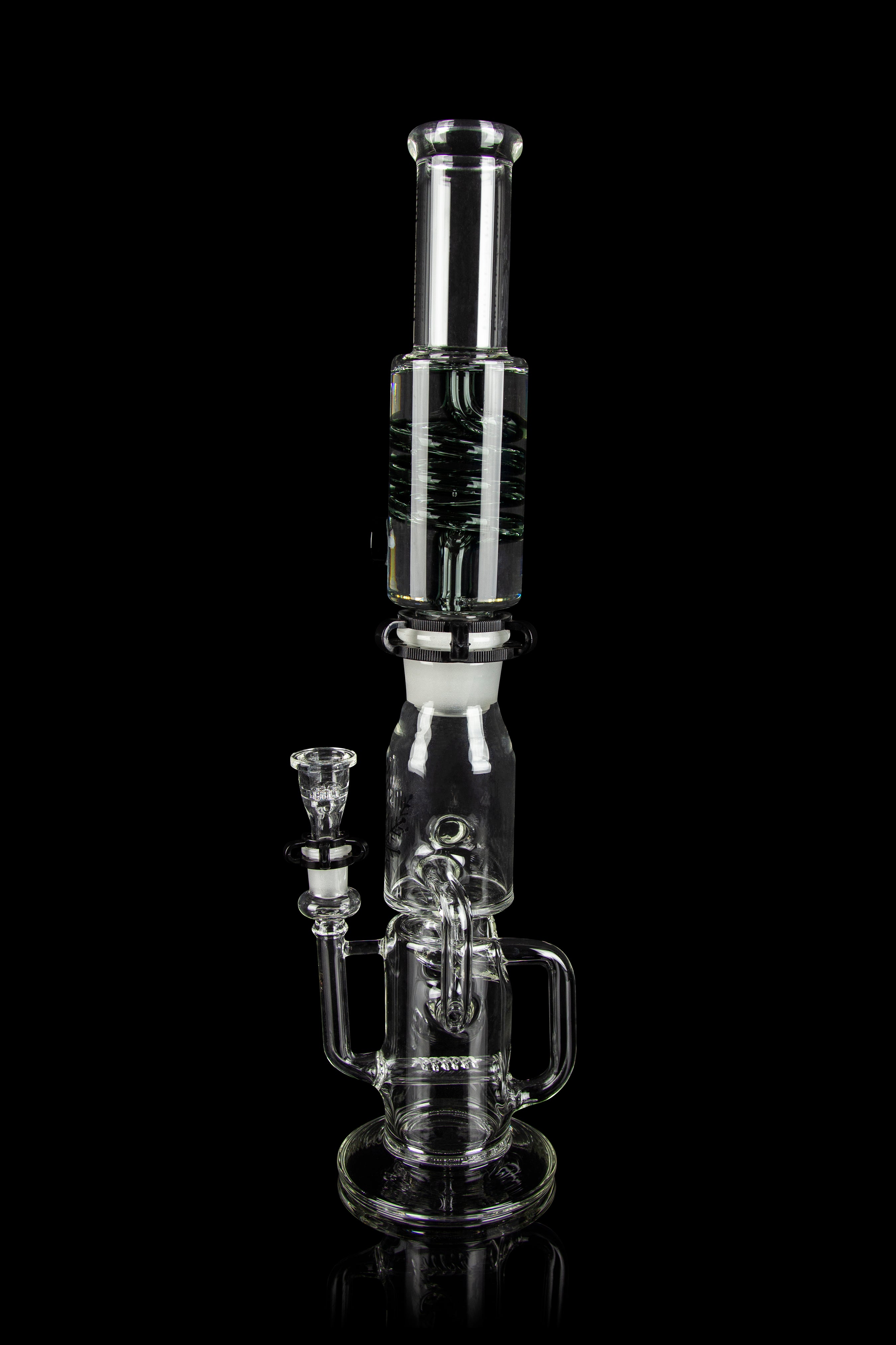 Clear glass water pipe (rig) with intricate bubbler design, isolated on black.